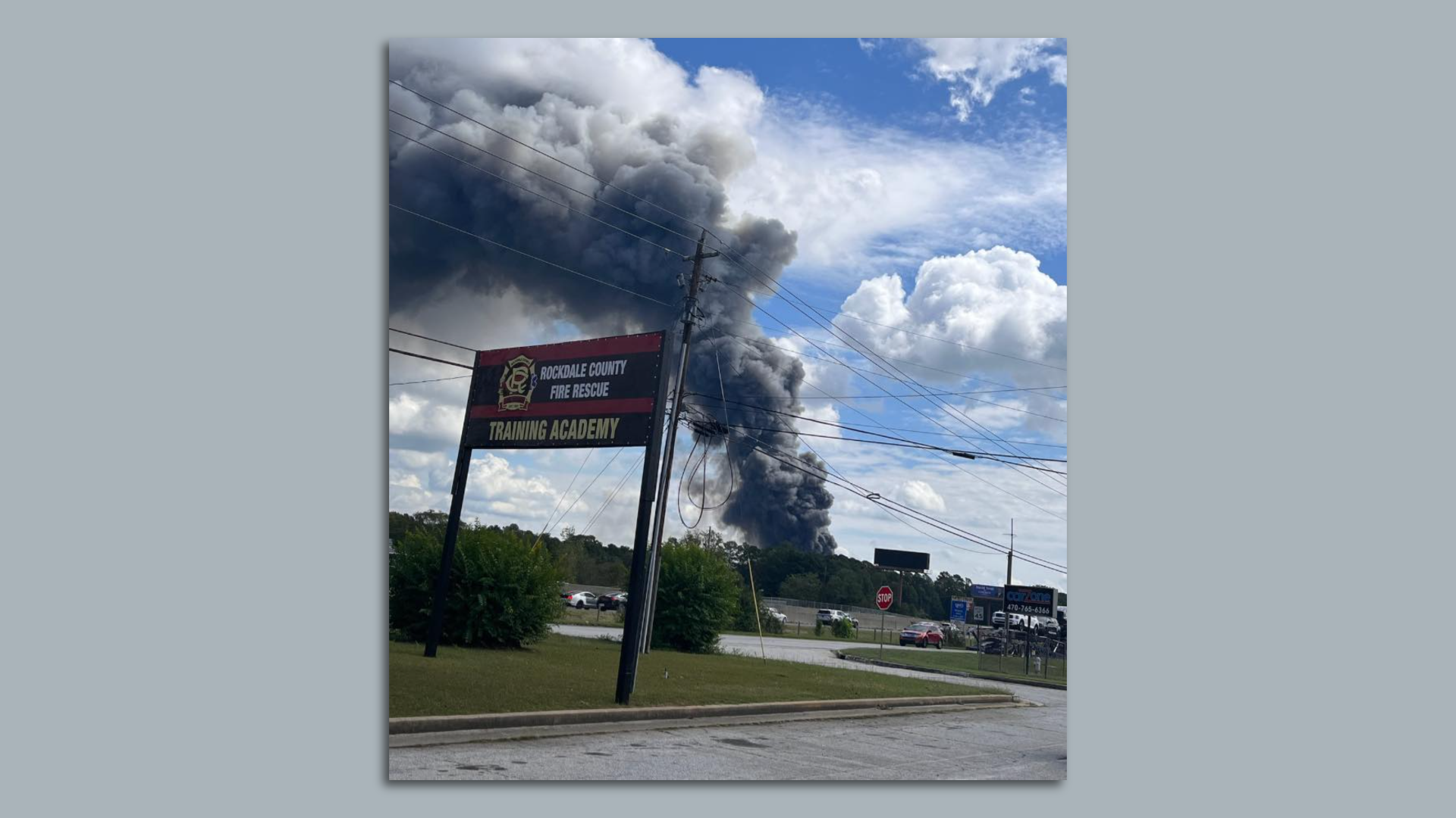 A photo of a smoke plume past the treeline and a large 