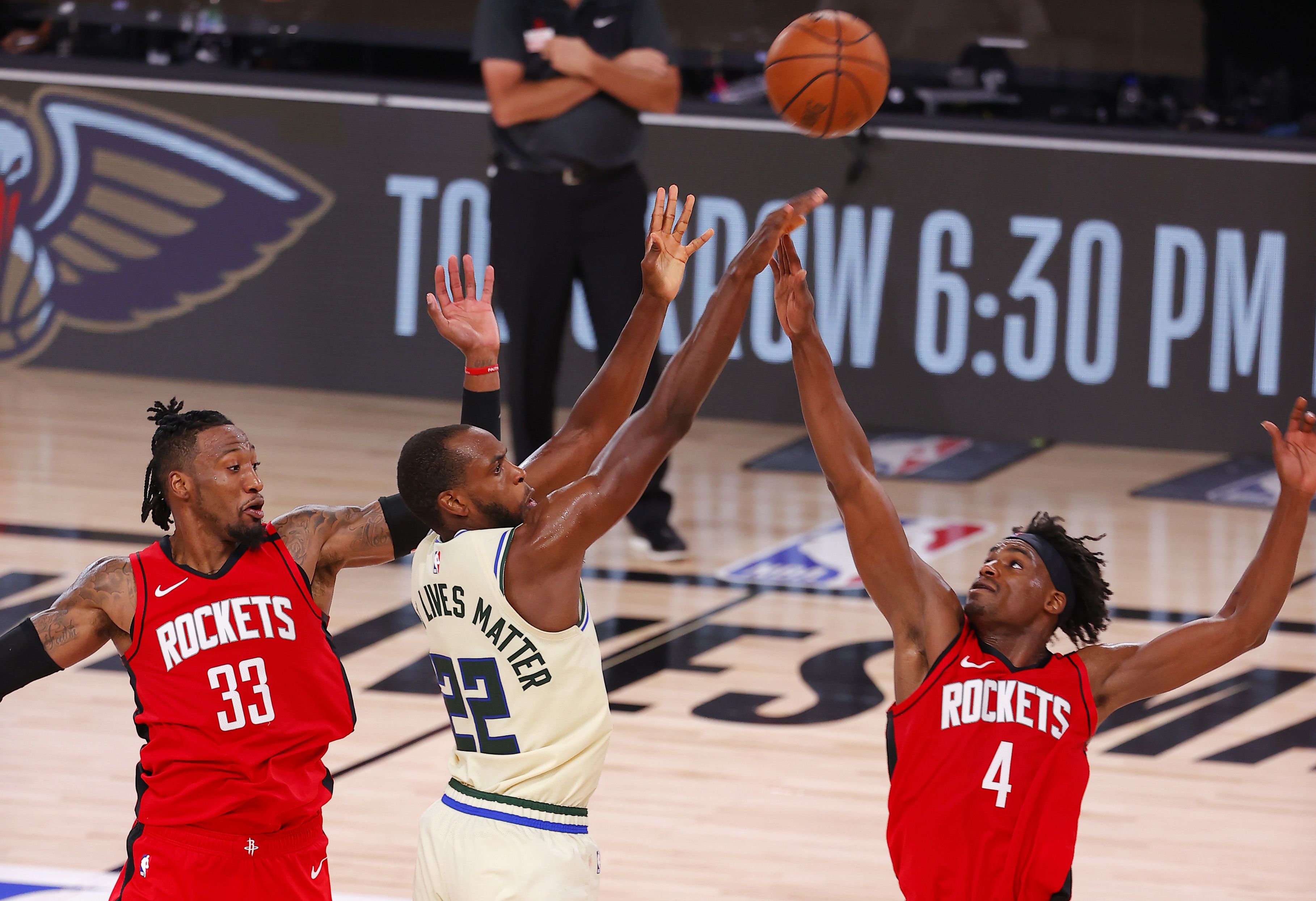 Rockets players trying to block Bucks player's shot