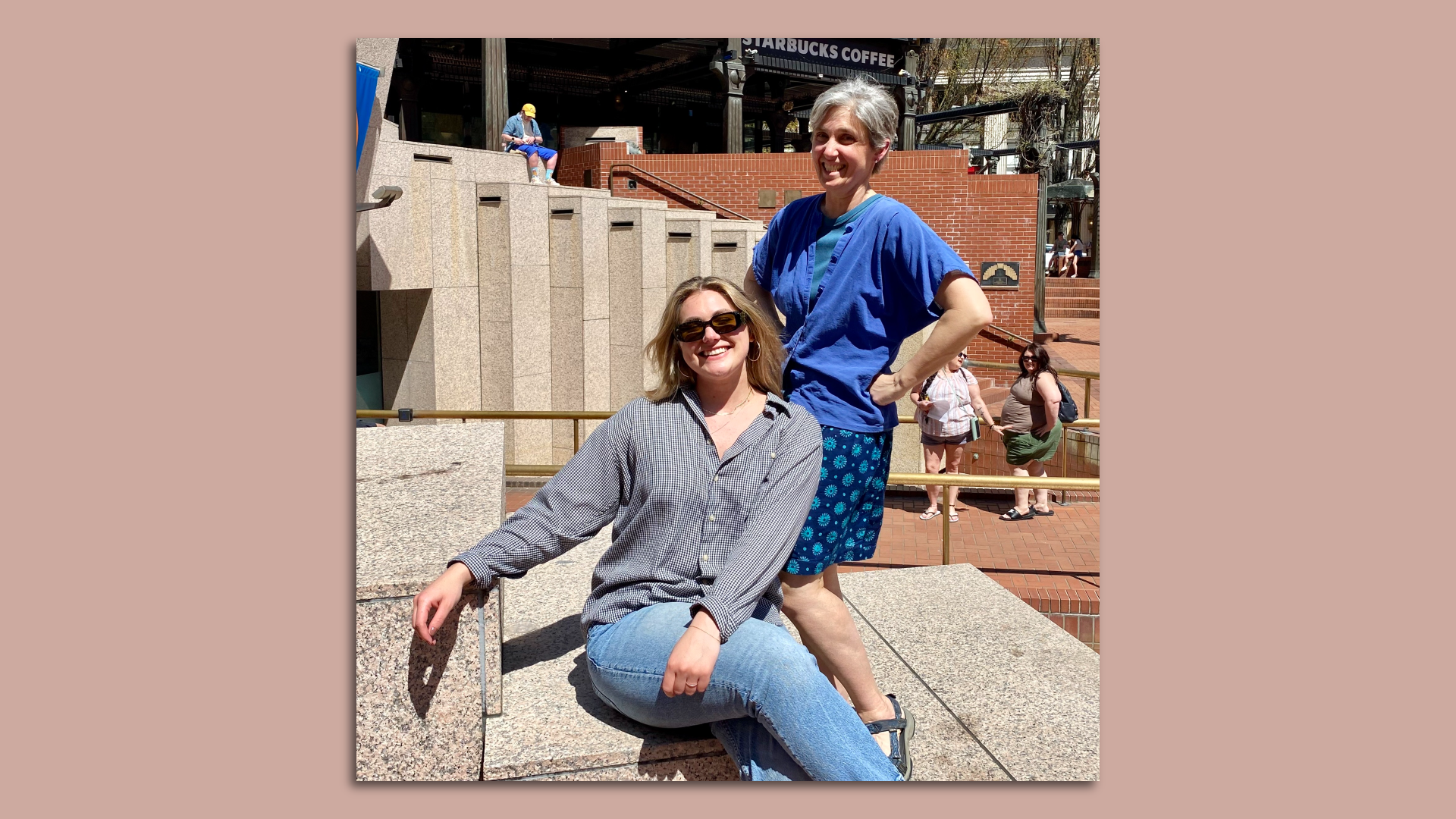 A photo of two people, one sitting and one standing, in a public square in Portland, Oregon.