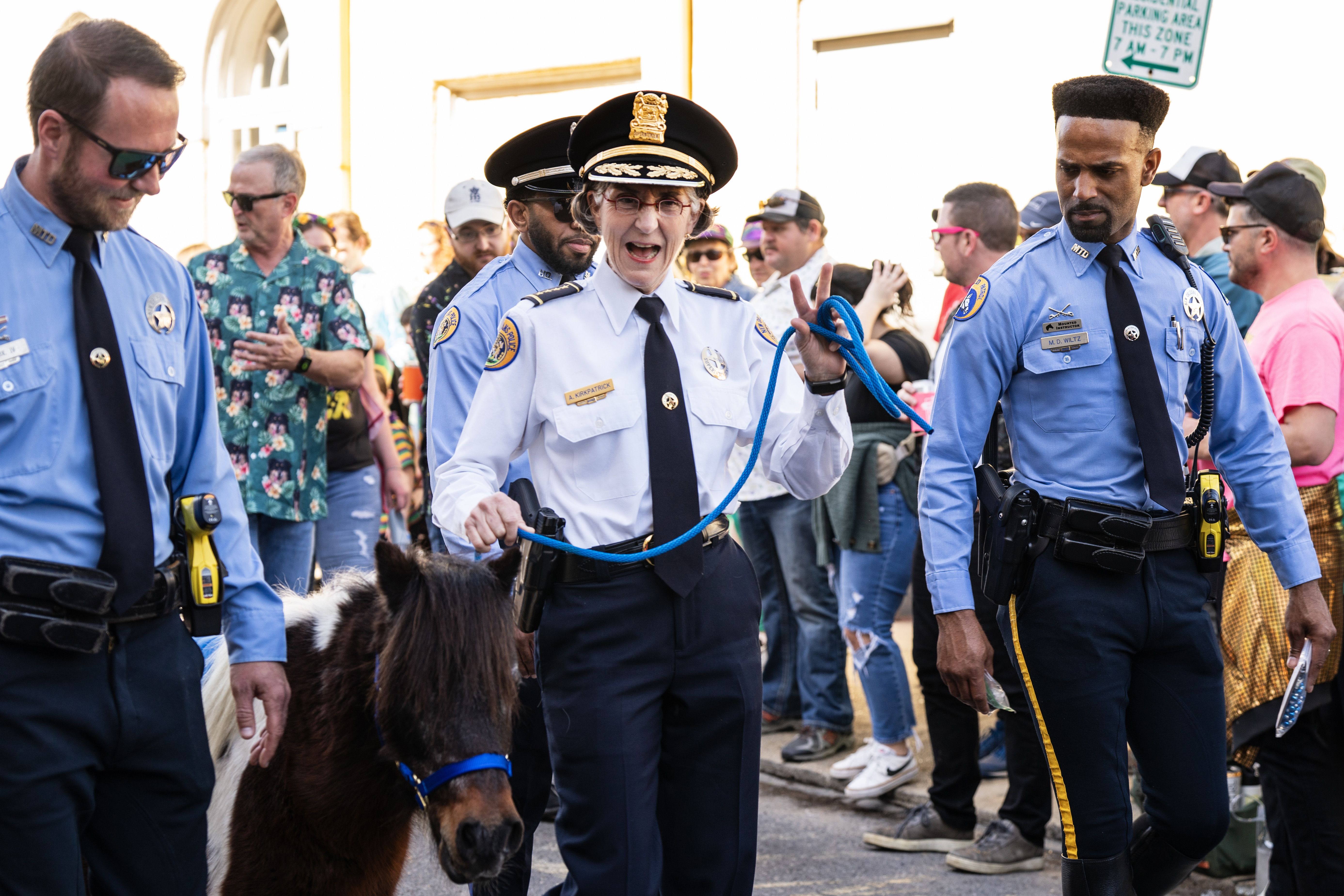NOPD chief Anne Kirkpatrick smiles at the camera as she walks the parade route with a mini pony.