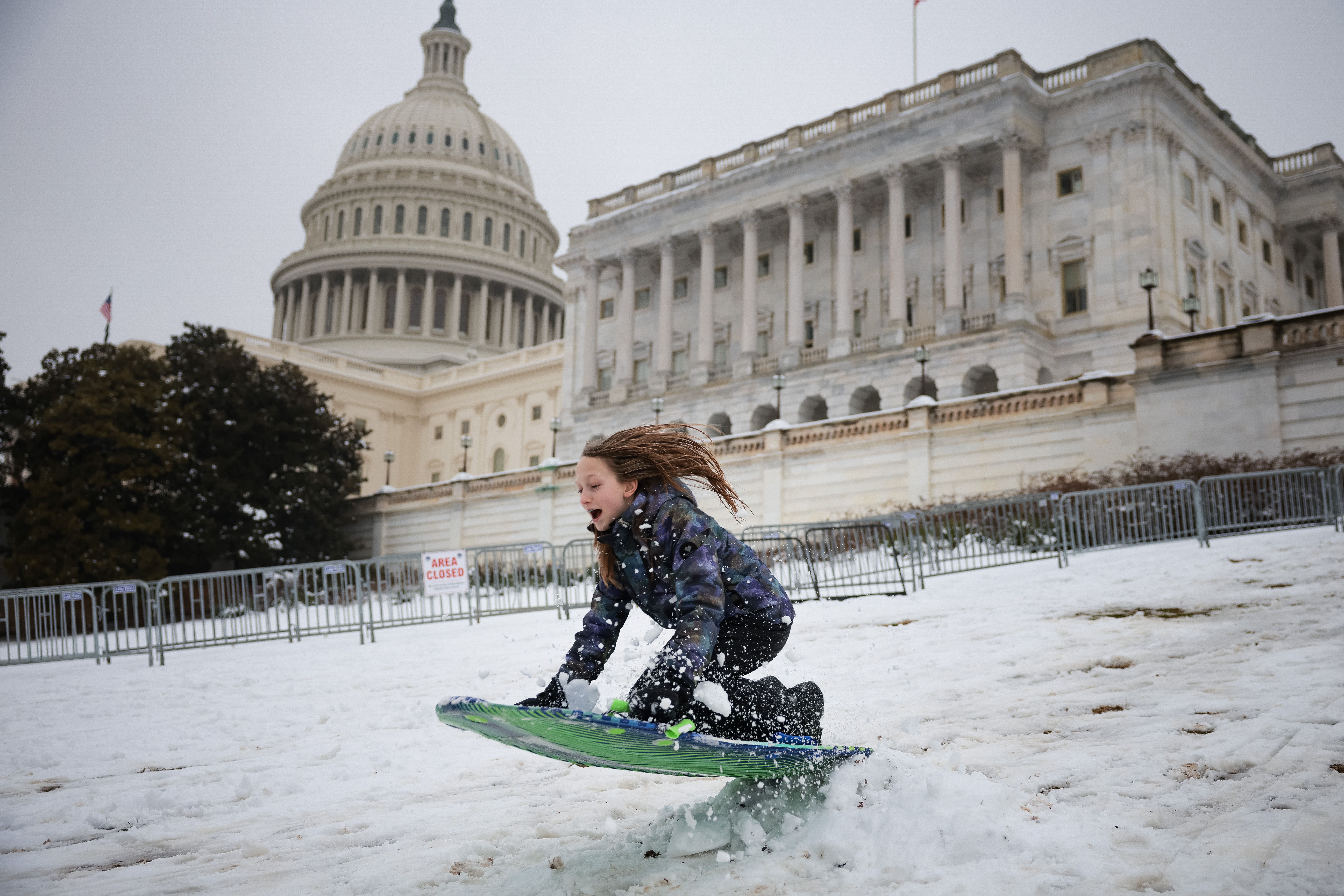 A moment of joy: Sledding on Capitol Hill during D.C.'s February winter storm, which dropped more than 5 inches of snow around the DMV. Photo: Kayla Bartkowski/Getty Images