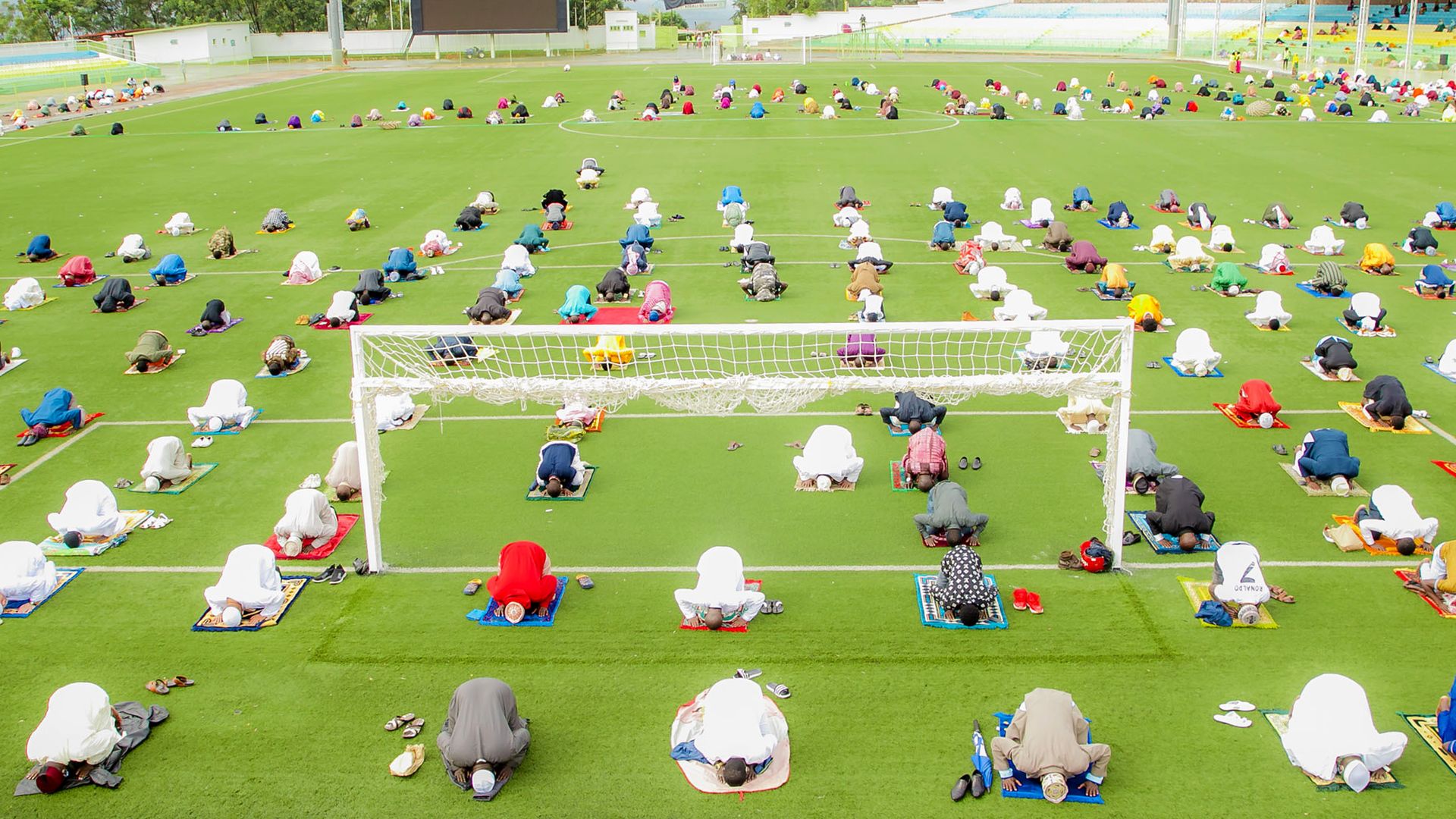 Muslims wearing protective face masks gather to perform Eid-al-fitr prayer amid the novel type of coronavirus (COVID-19) pandemic at Nyamirambo Stadium in Kigali, Rwanda on May 13,