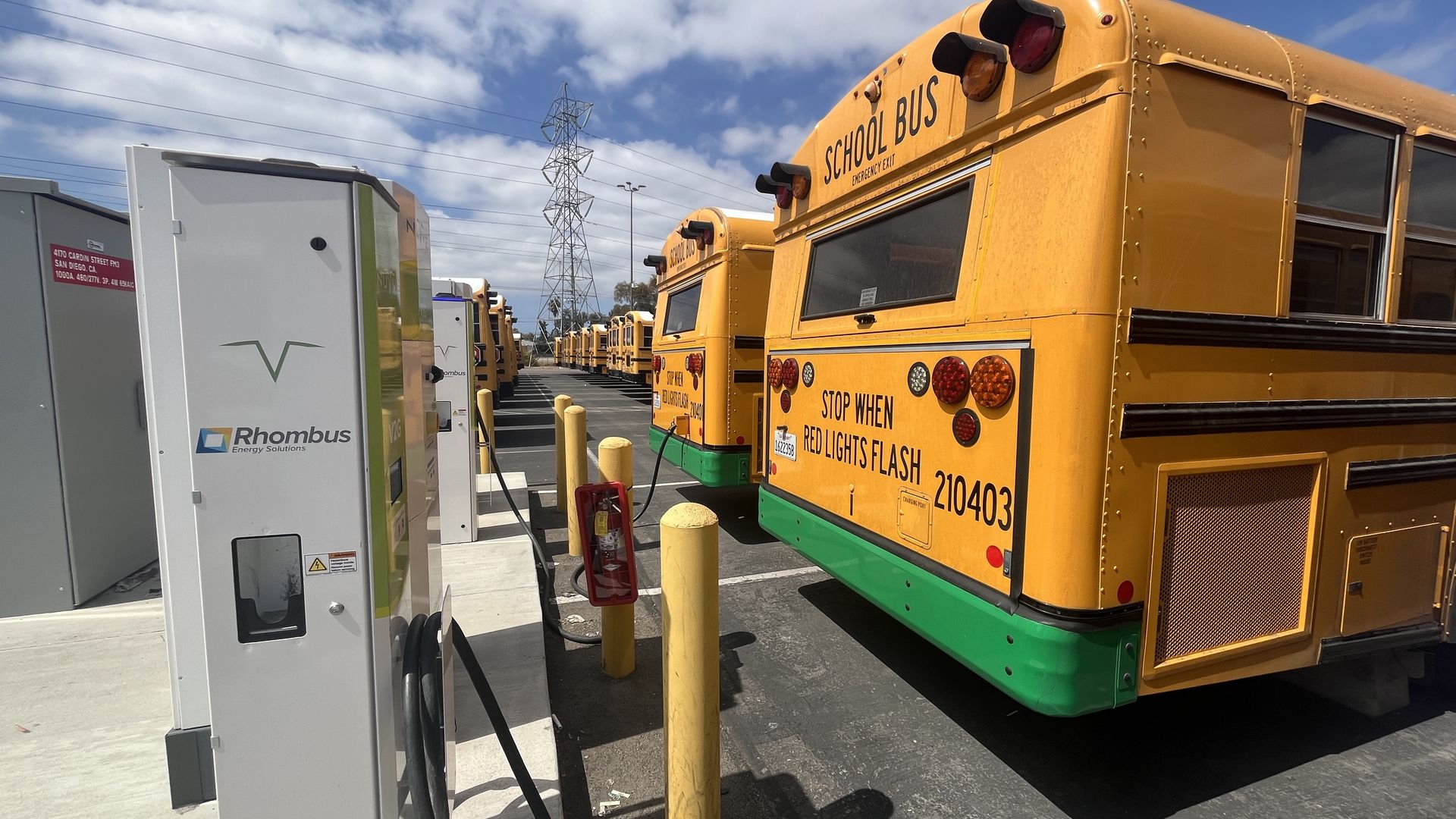 Electric school buses charging in a parking lot.