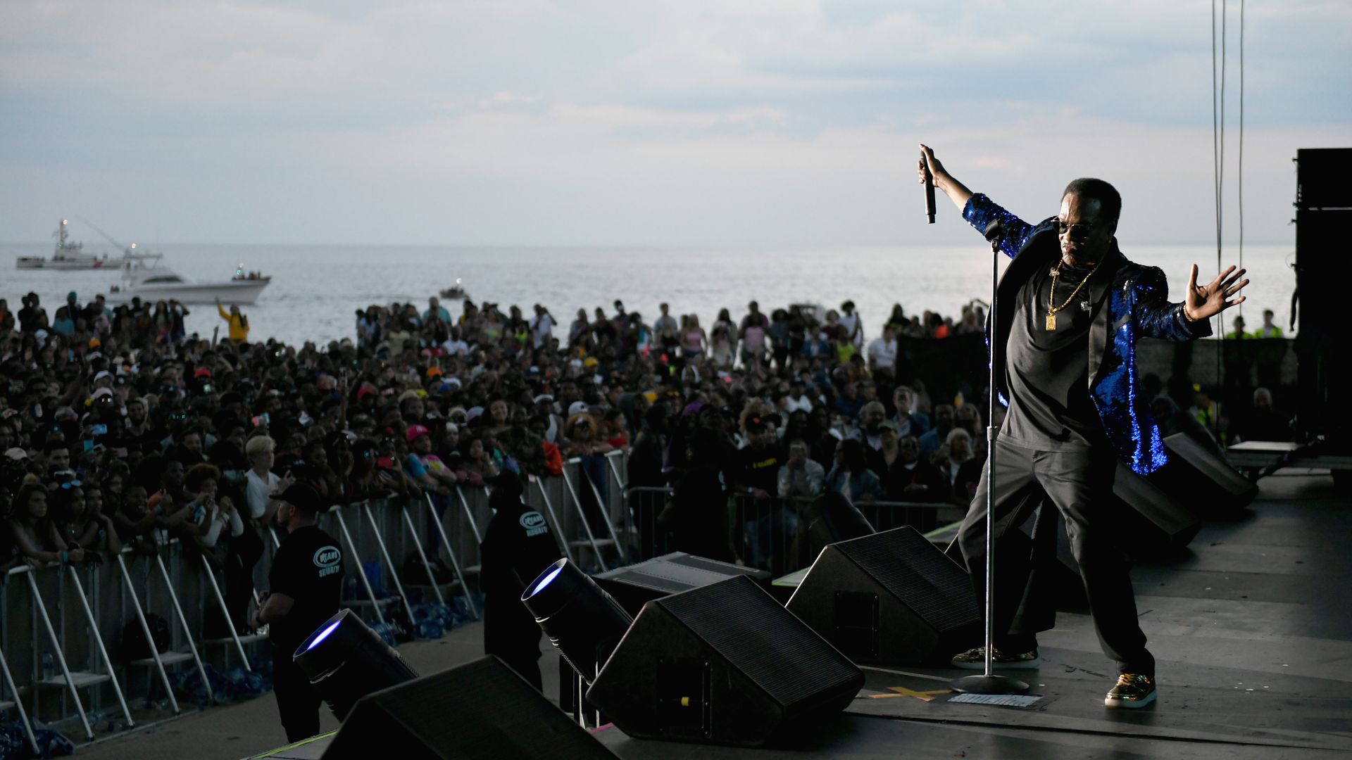 Charlie Wilson performs in front of a large crowd overlooking the water. 