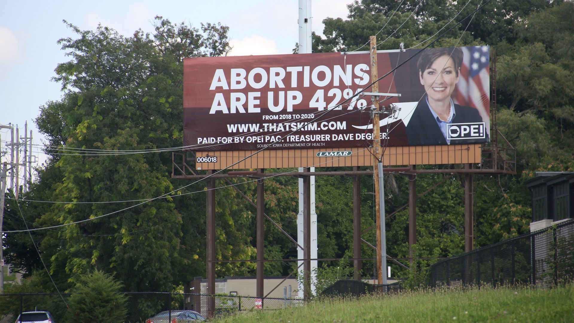A billboard of Gov. Kim Reynolds alongside I-235 East.