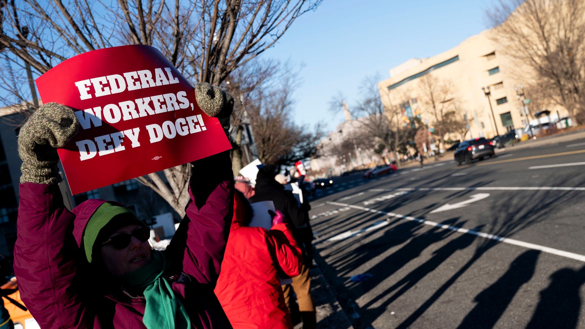 Protesters demonstrating against federal job cuts outside a U.S. government office building. 