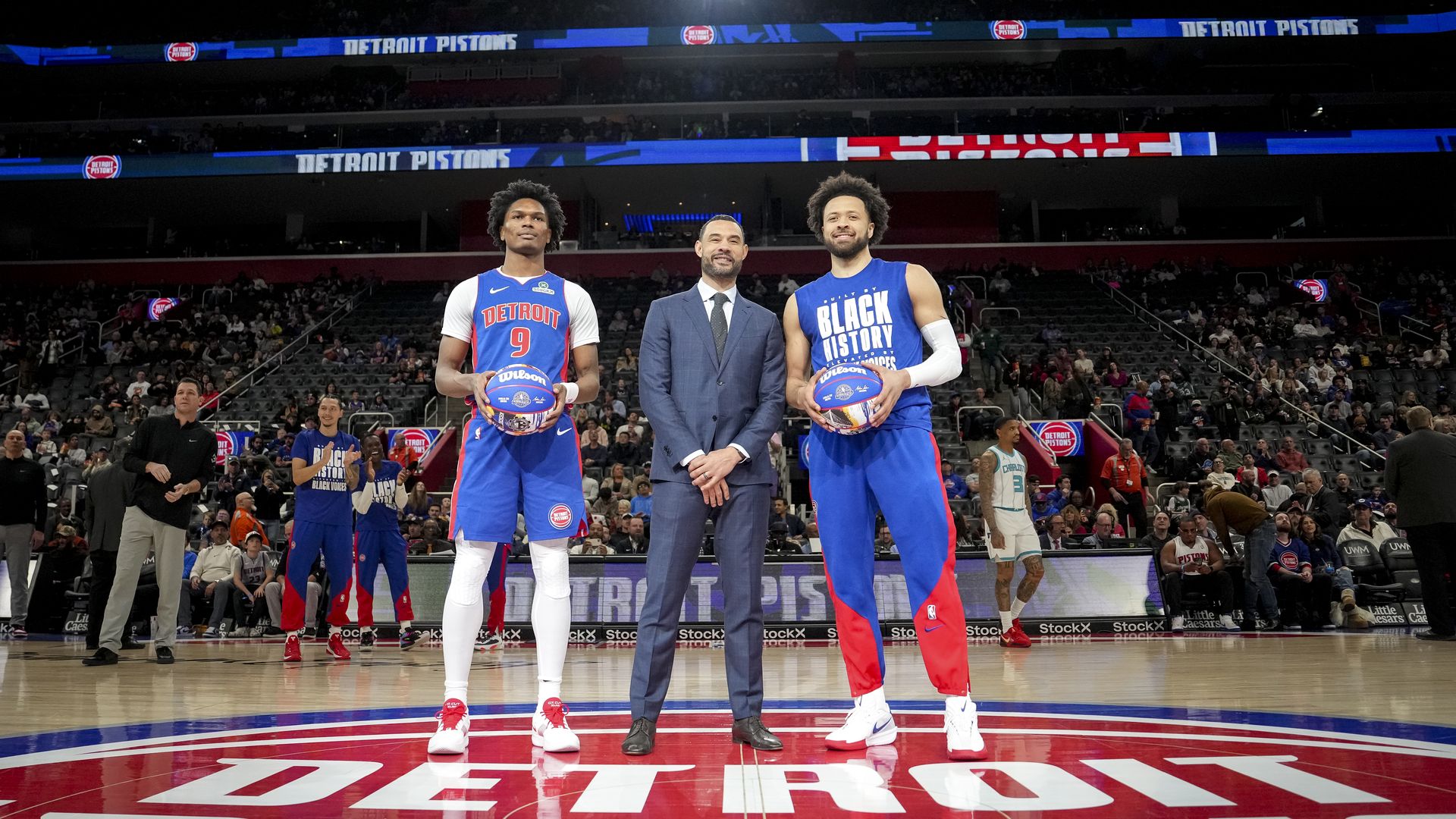 Trajan Langdon, the Pistons' president of basketball operations, stands between Cade Cunningham, right, and Ausar Thompson in February.