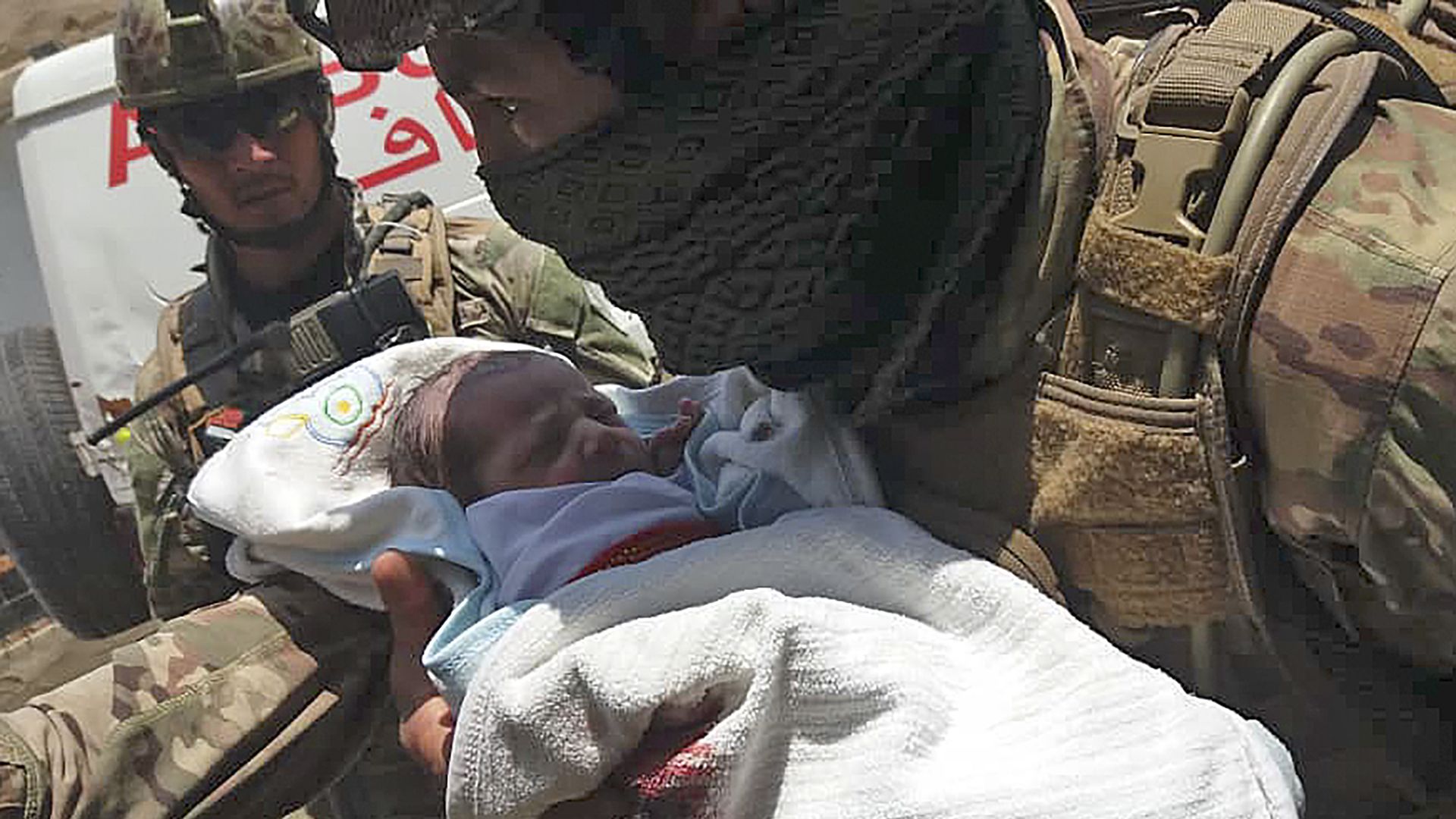In this image, a baby is swaddled in a blood stained blanket