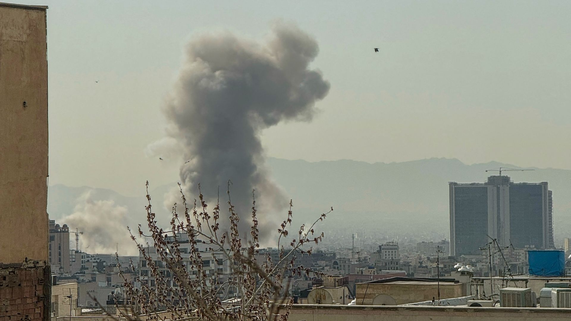 A plume of smoke rises over Tehran after a reported explosion on February 28, 2026