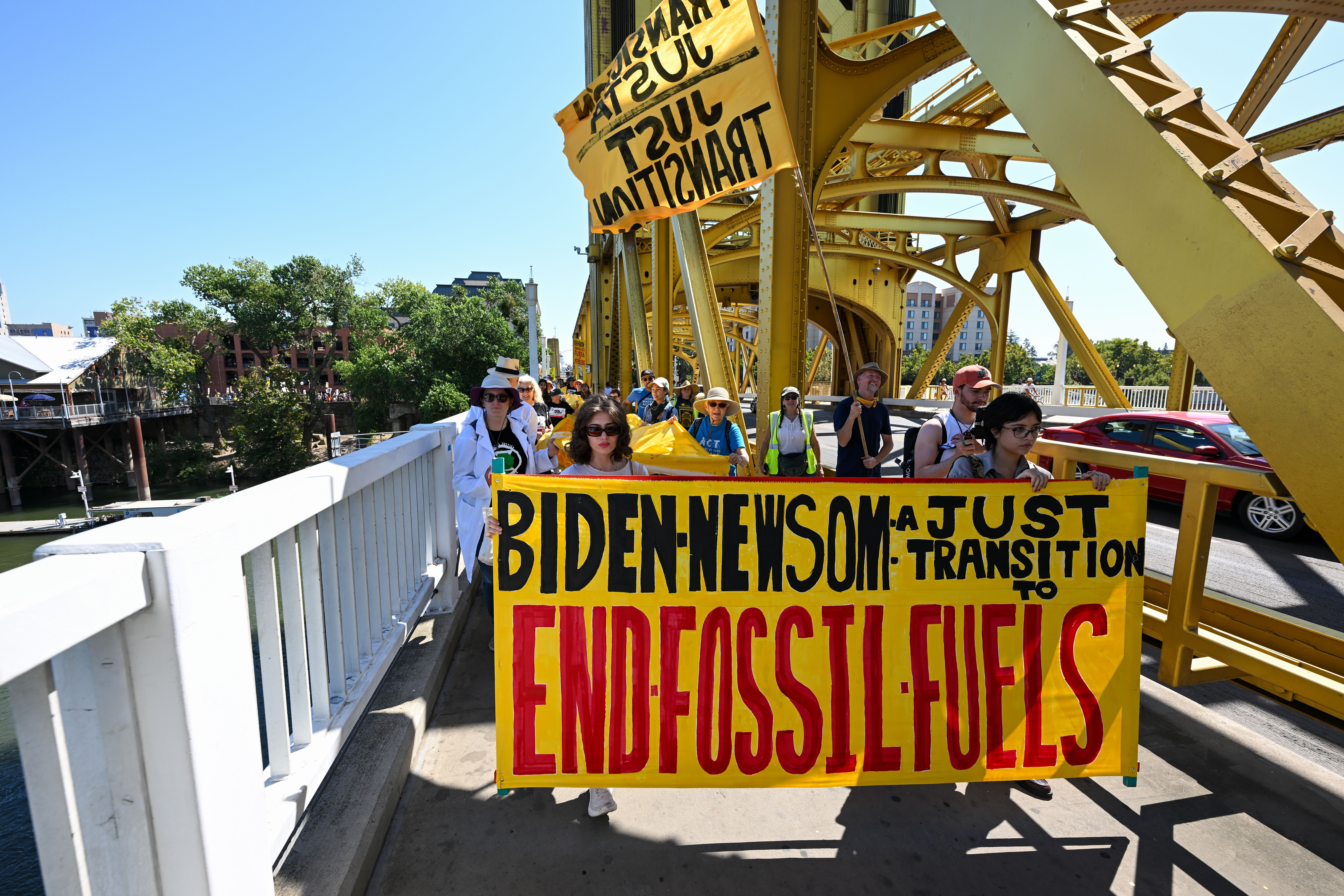 Activists hold a large banner with a message for President Biden and California Gov. Gavin Newsom on the Tower Bridge as hundreds of climate change activists are gathered at Old Sacramento Waterfront, to protest in Sacramento, California, on Sept. 17. 