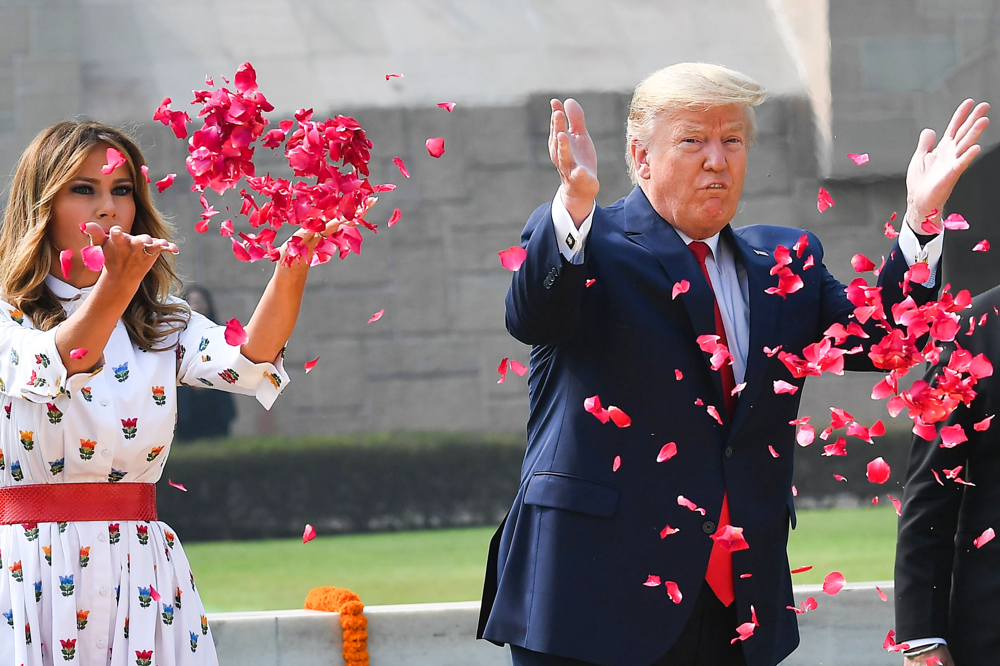 President Donald Trump and First Lady Melania Trump spray rose petals to pay tribute at Raj Ghat, the memorial for Indian independence icon Mahatma Gandhi, in New Delhi on February 25