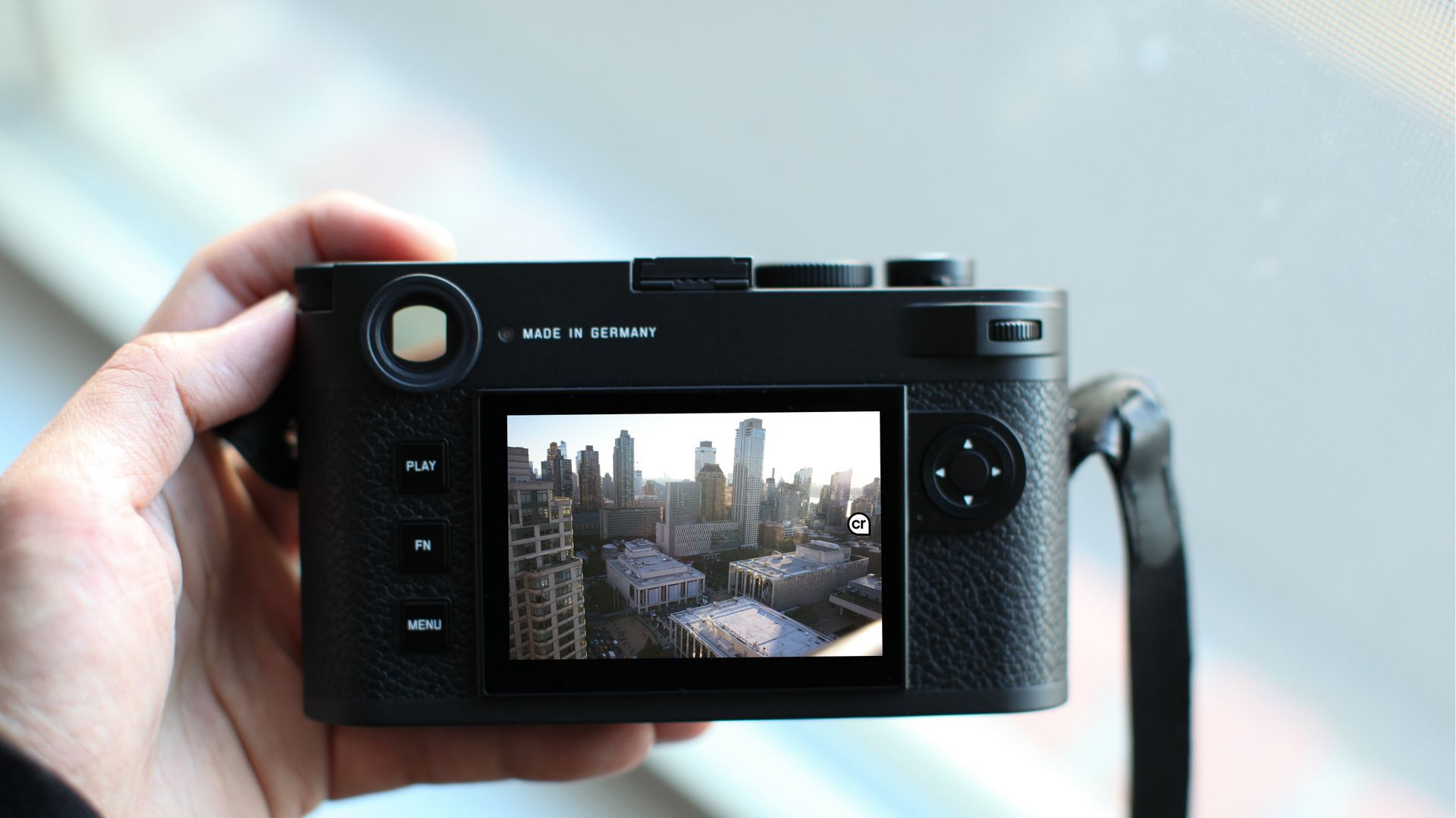 a Leica digital camera held by a hand