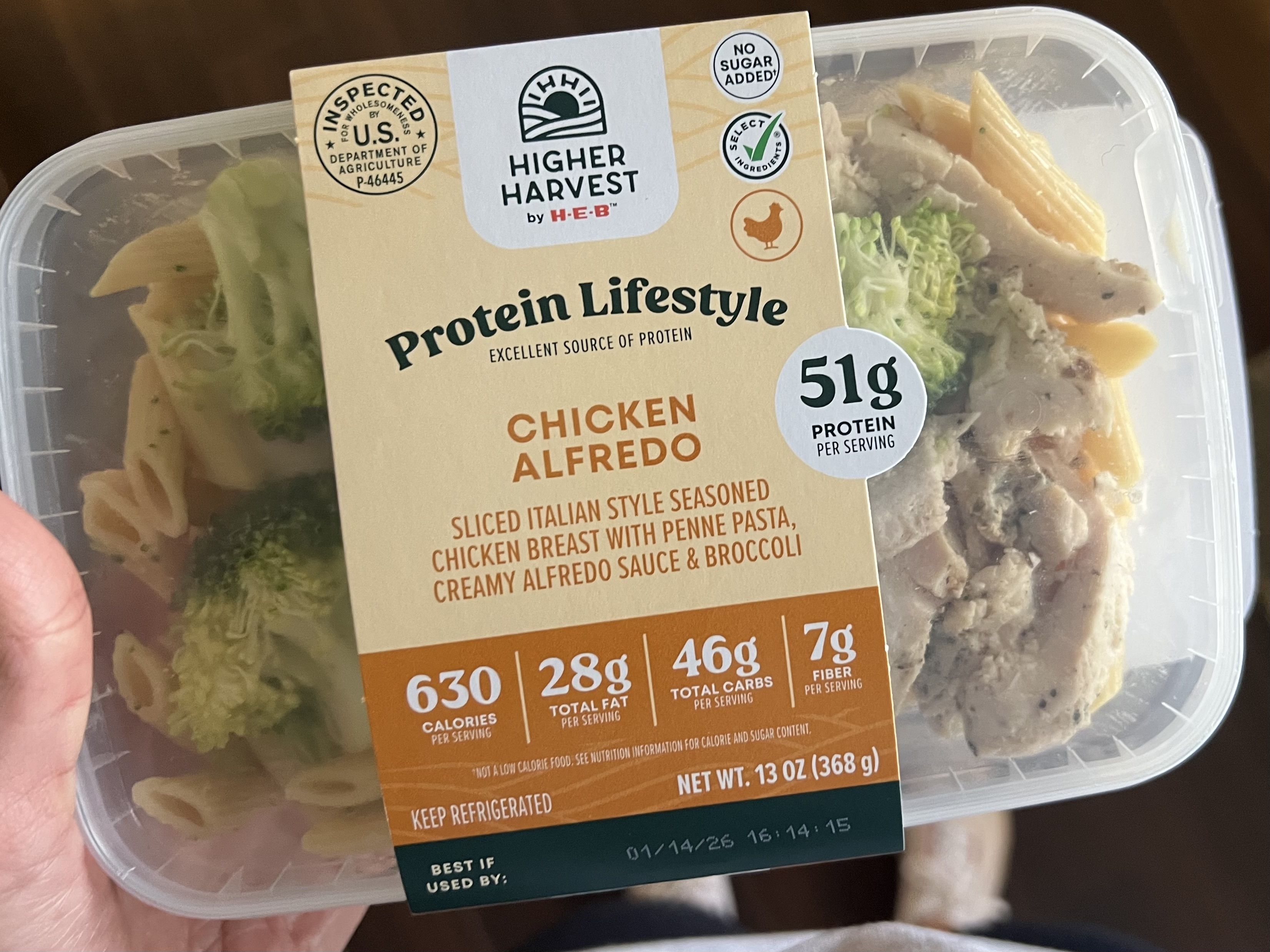 Prepackaged Higher Harvest by H-E-B Chicken Alfredo meal with sliced Italian seasoned chicken breast, penne pasta, creamy Alfredo sauce, broccoli, and nutrition facts on label.