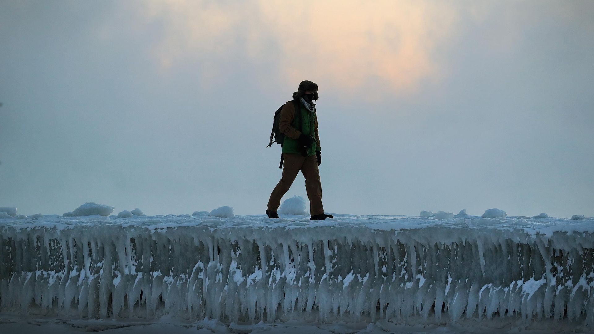 Man walks along ice in Chicago.