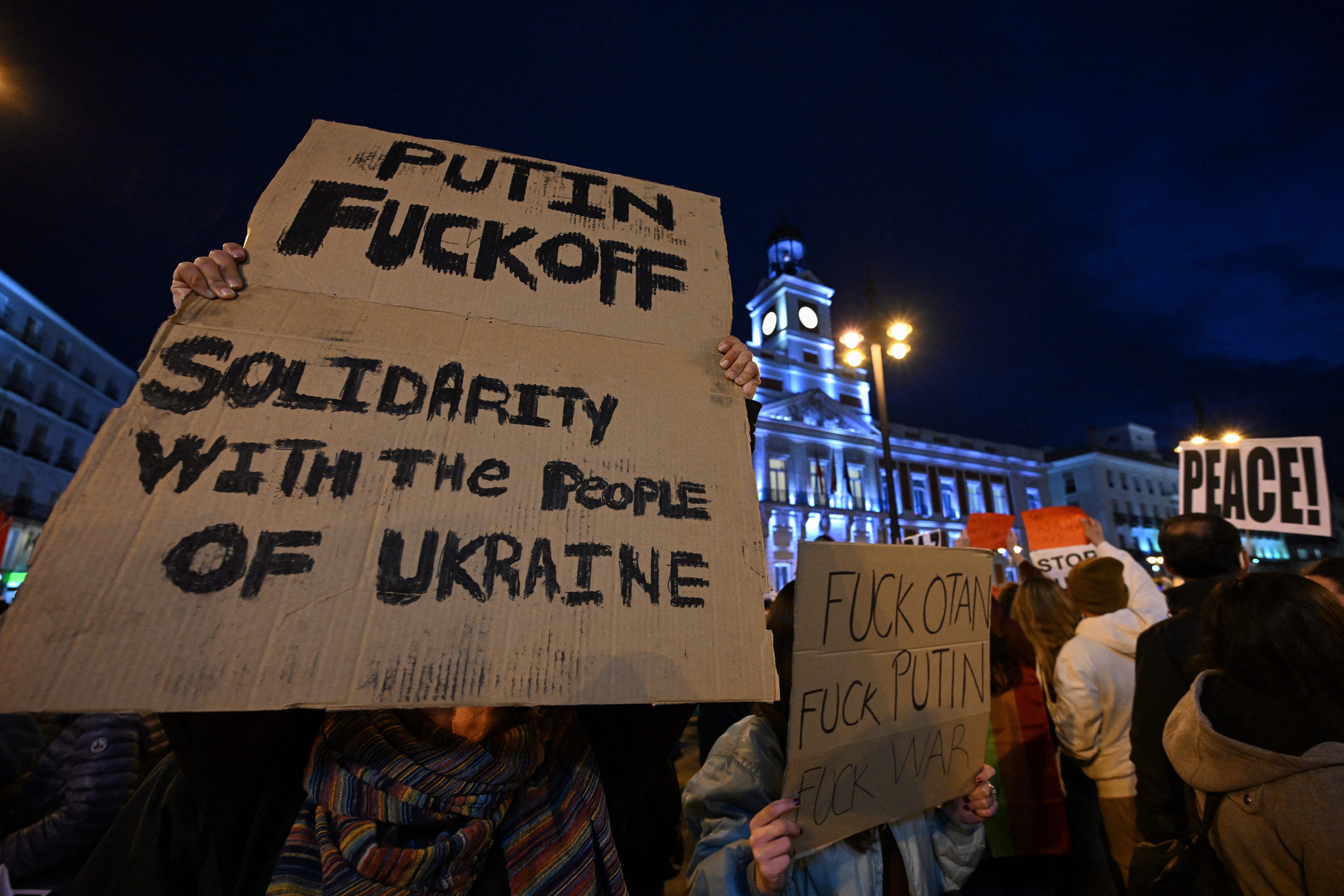 Photo of people holding signs, one of which says "Putin fuck off, solidarity with the people of Ukraine"