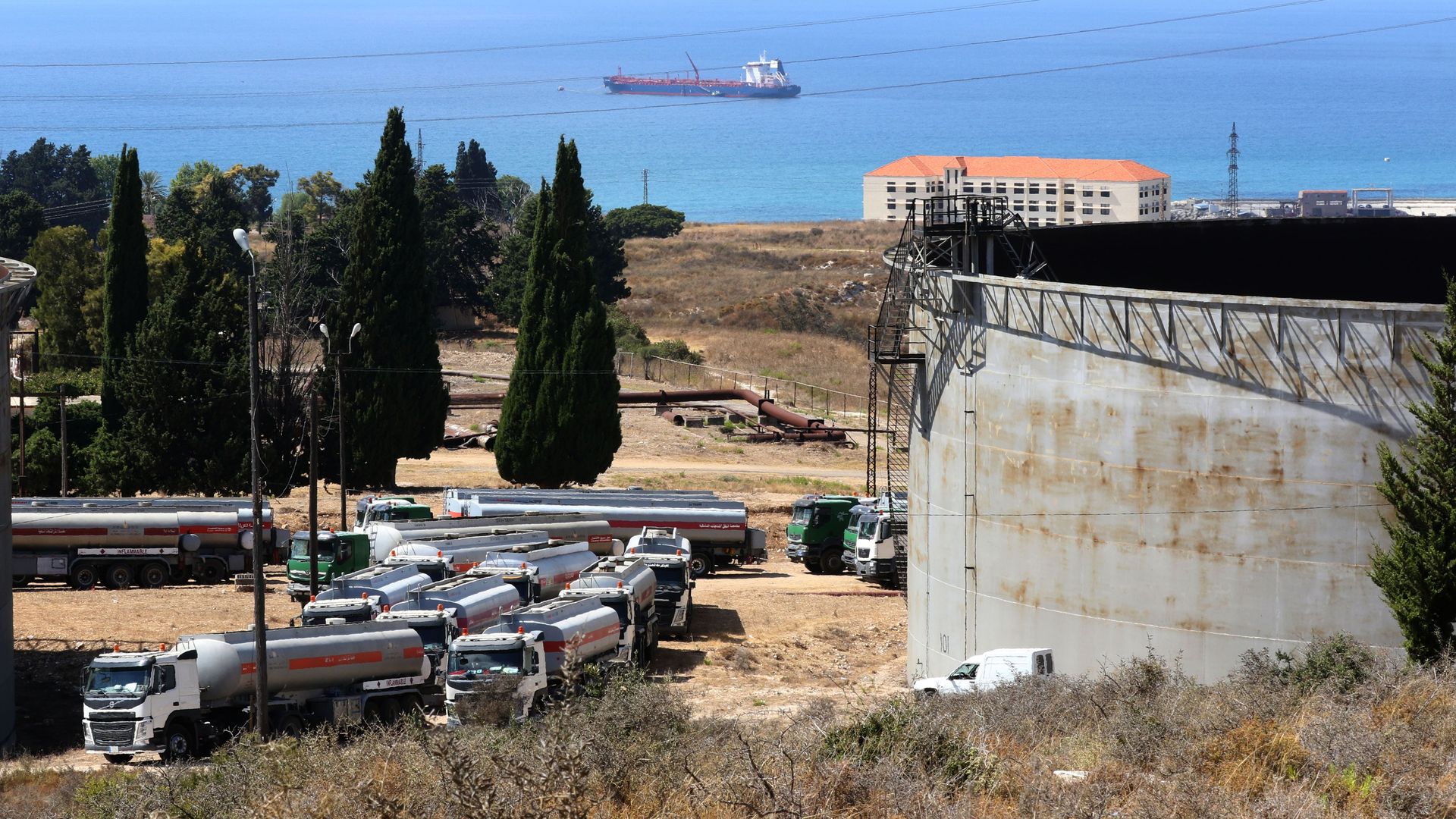 Tanker trucks filled with fuel offered by Iraq wait to empty their content at the oil refinery of Zahrani, near the southerm Lebanese city of Sidon (Saida) on August 20, 2020. 