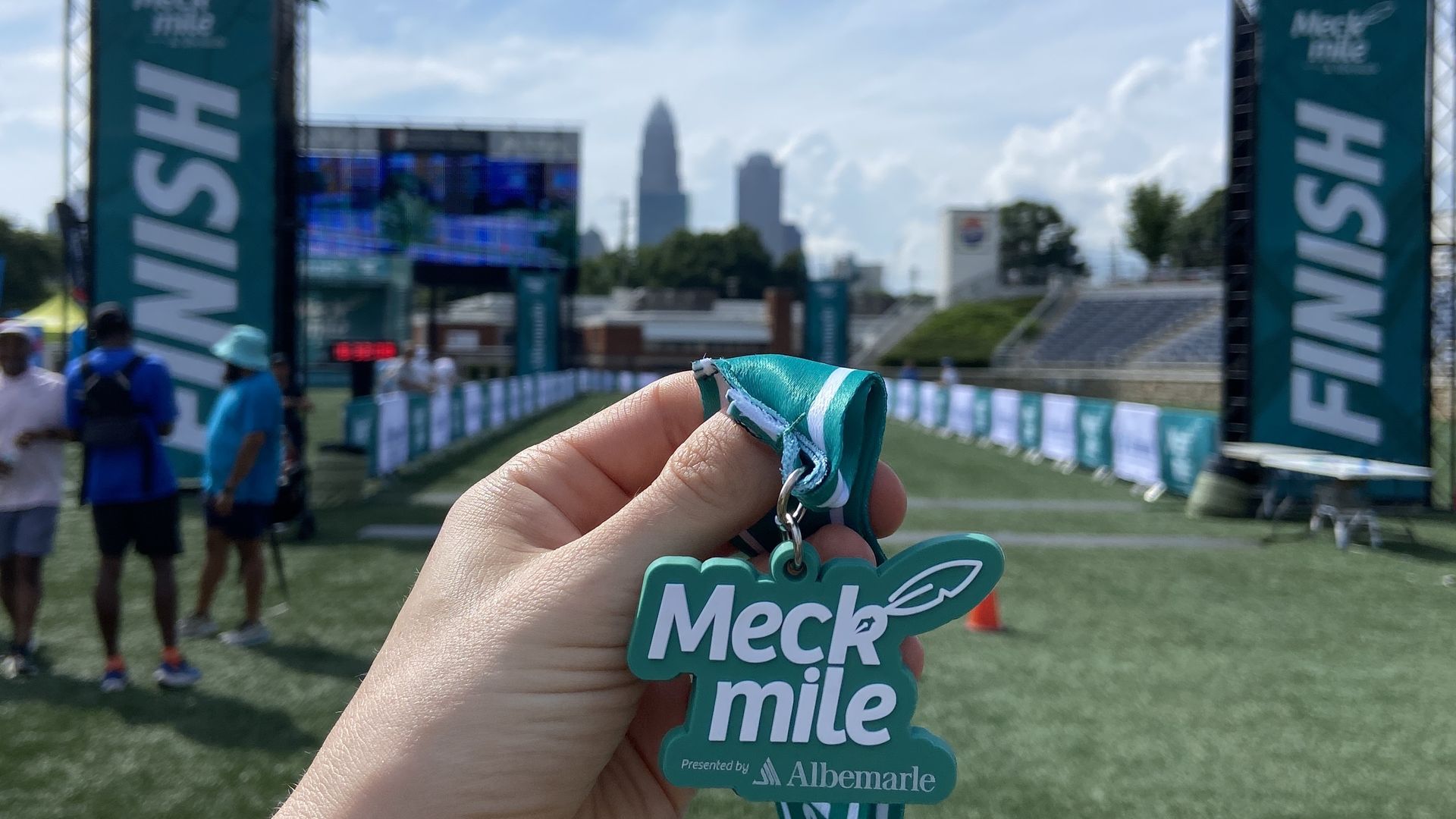 Meck Mile medal in front of the Charlotte skyline.