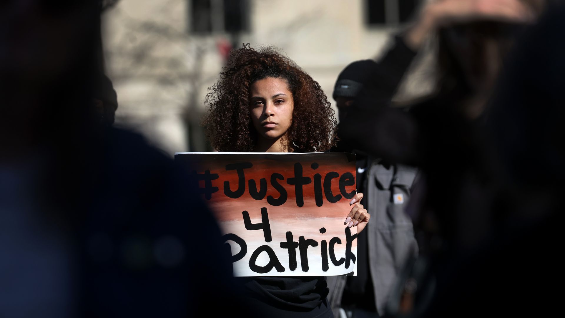 Photo of a protester holding a sign that says "Justice 4 Patrick"