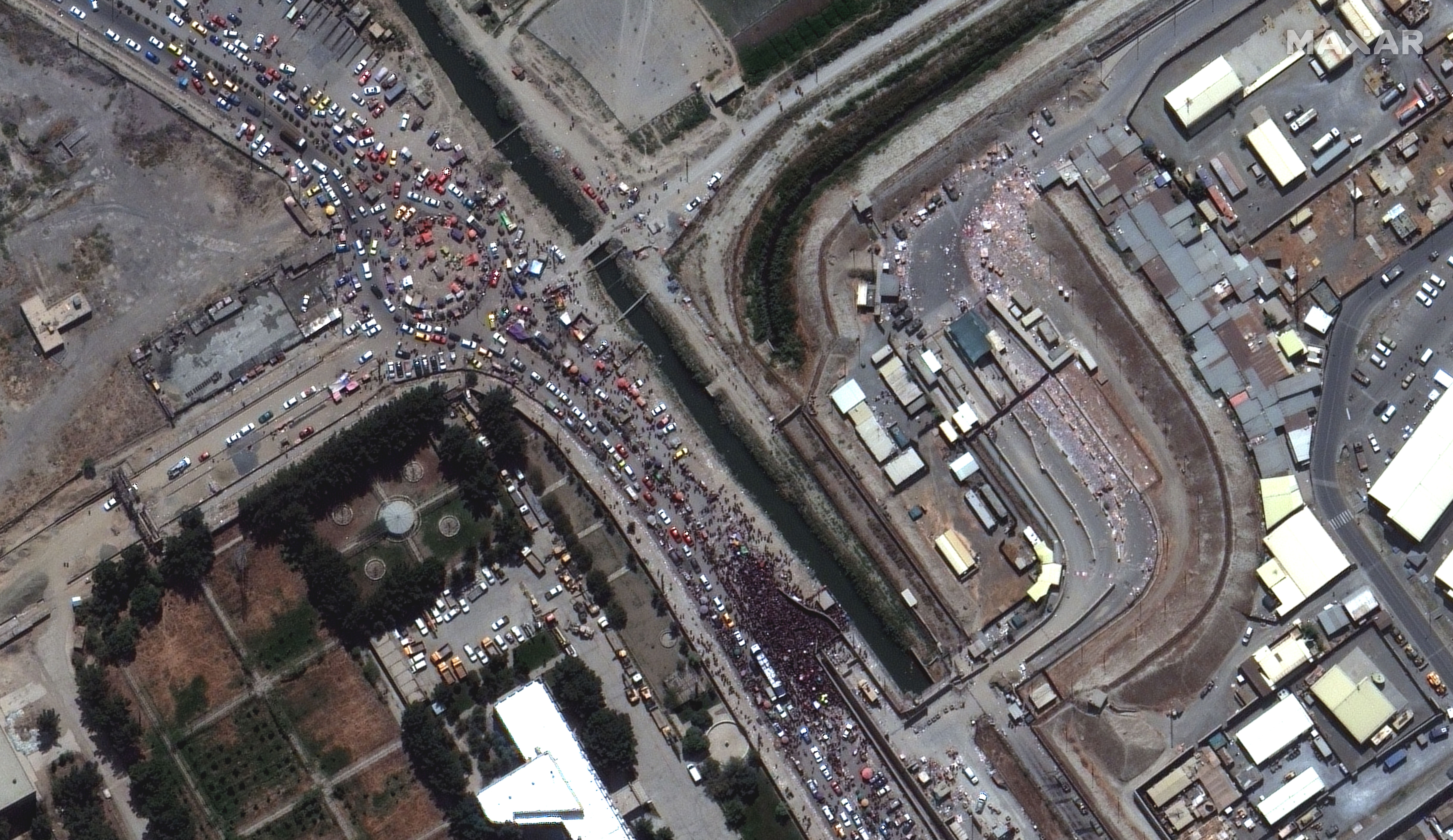 A satellite image of large crowds near the gate of the northern edge of Kabul's airport on Aug. 23