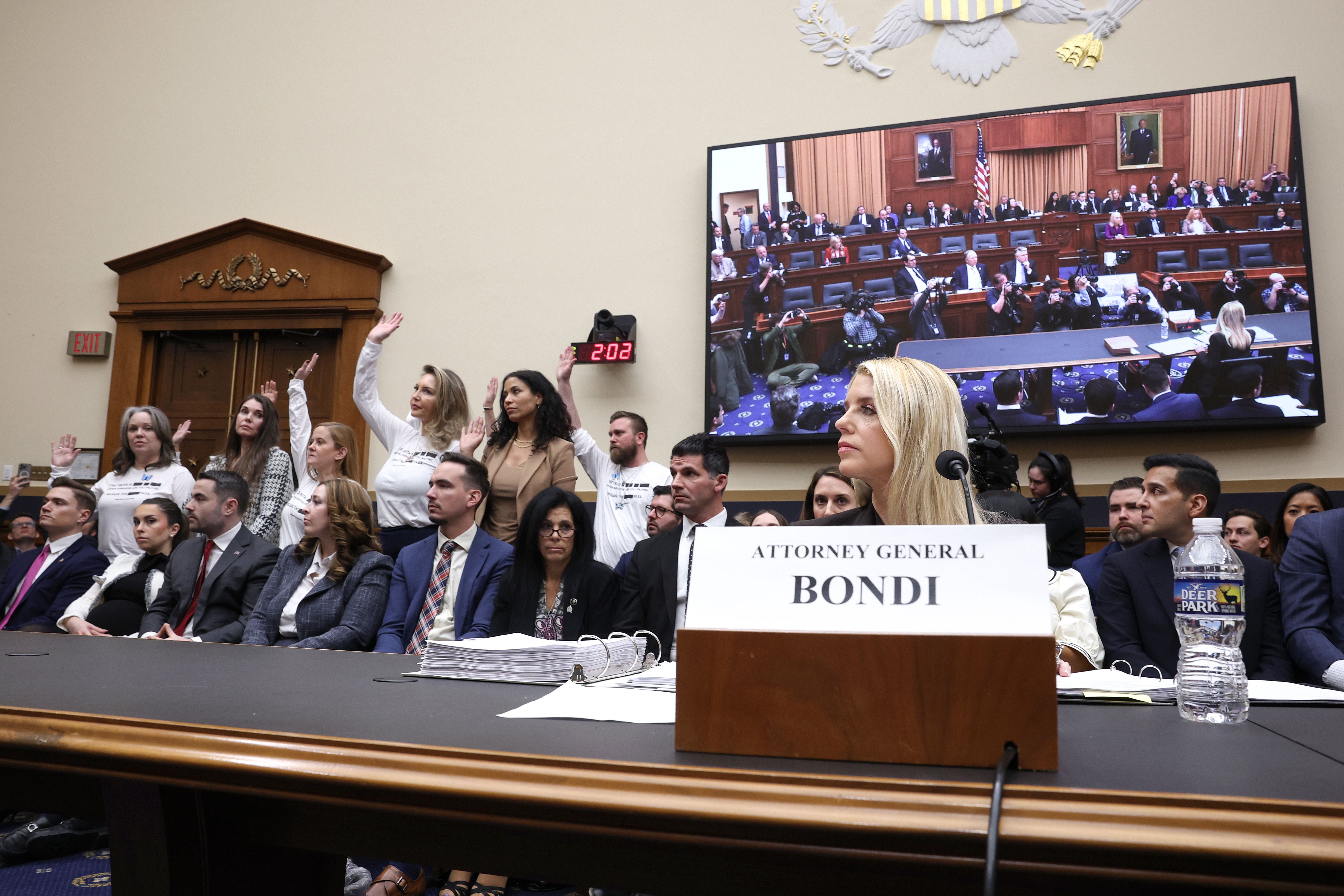 Survivors of Jeffrey Epstein stand as U.S. Attorney General Pam Bondi testifies before the House Judiciary Committee in the Rayburn House Office Building on February 11, 2026 in Washington, DC. 