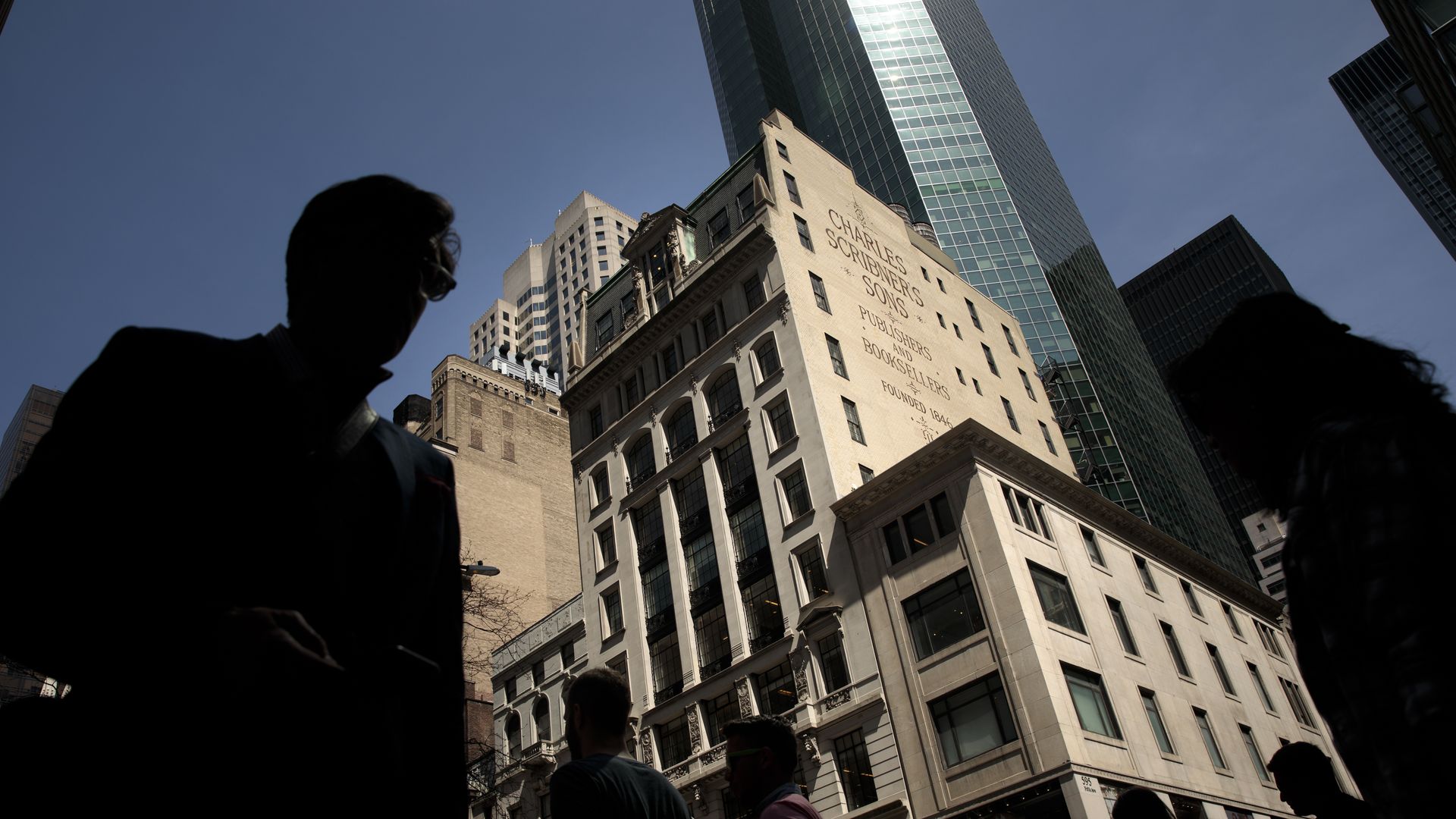 A man silhouetted in front of a high-rise building