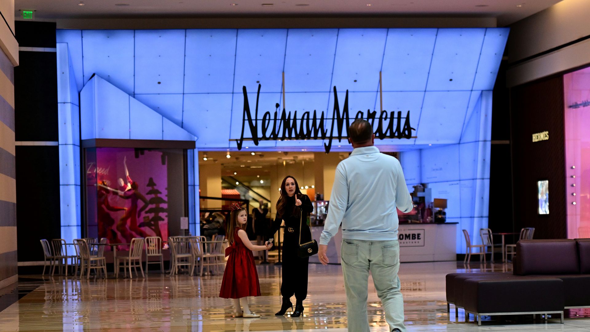 Shoppers in front of a Neiman Marcus inside an indoor mall