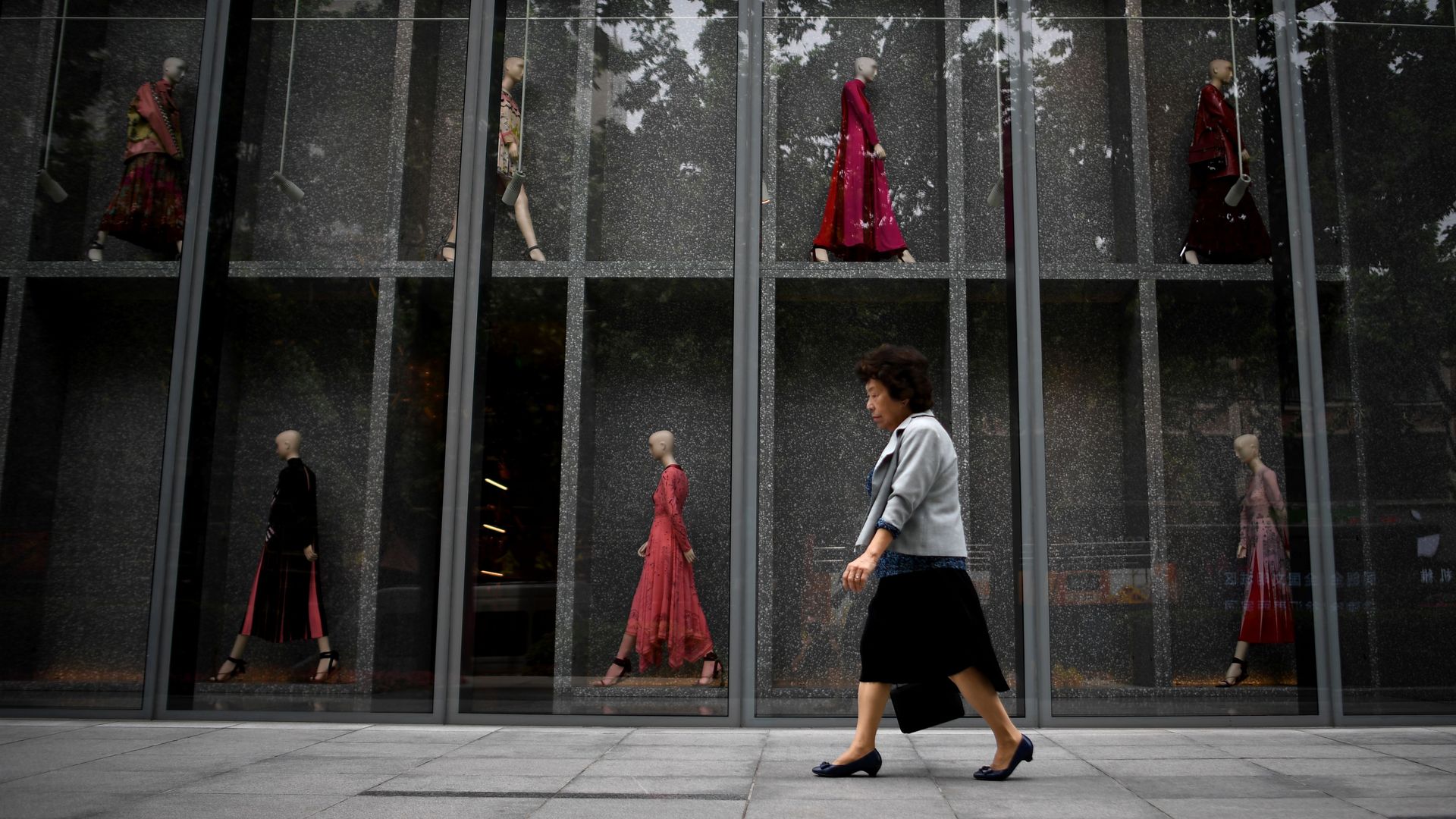 Chinese woman walking past mall