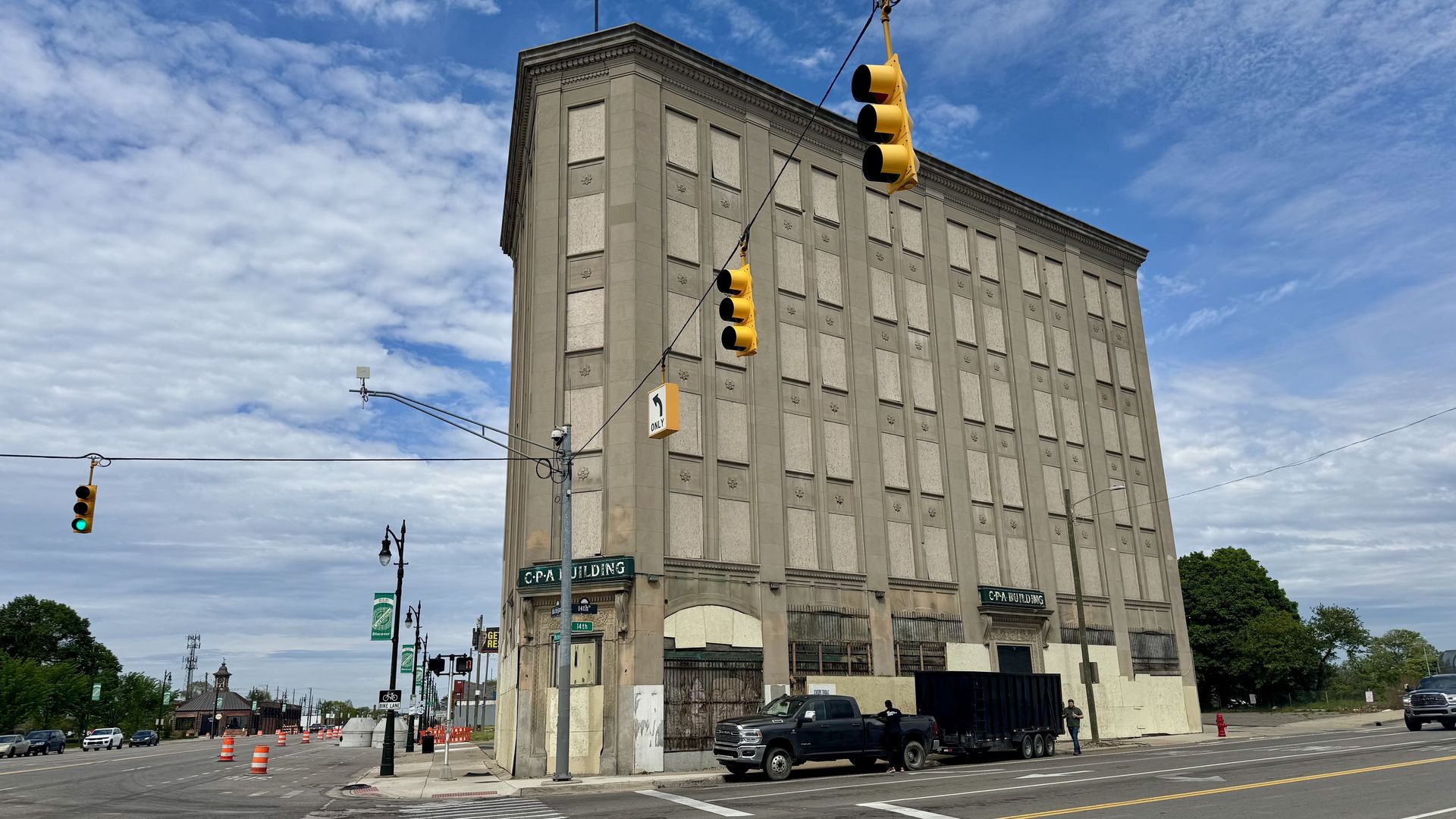 A tall and vacant building with architectural details and boarded up windows