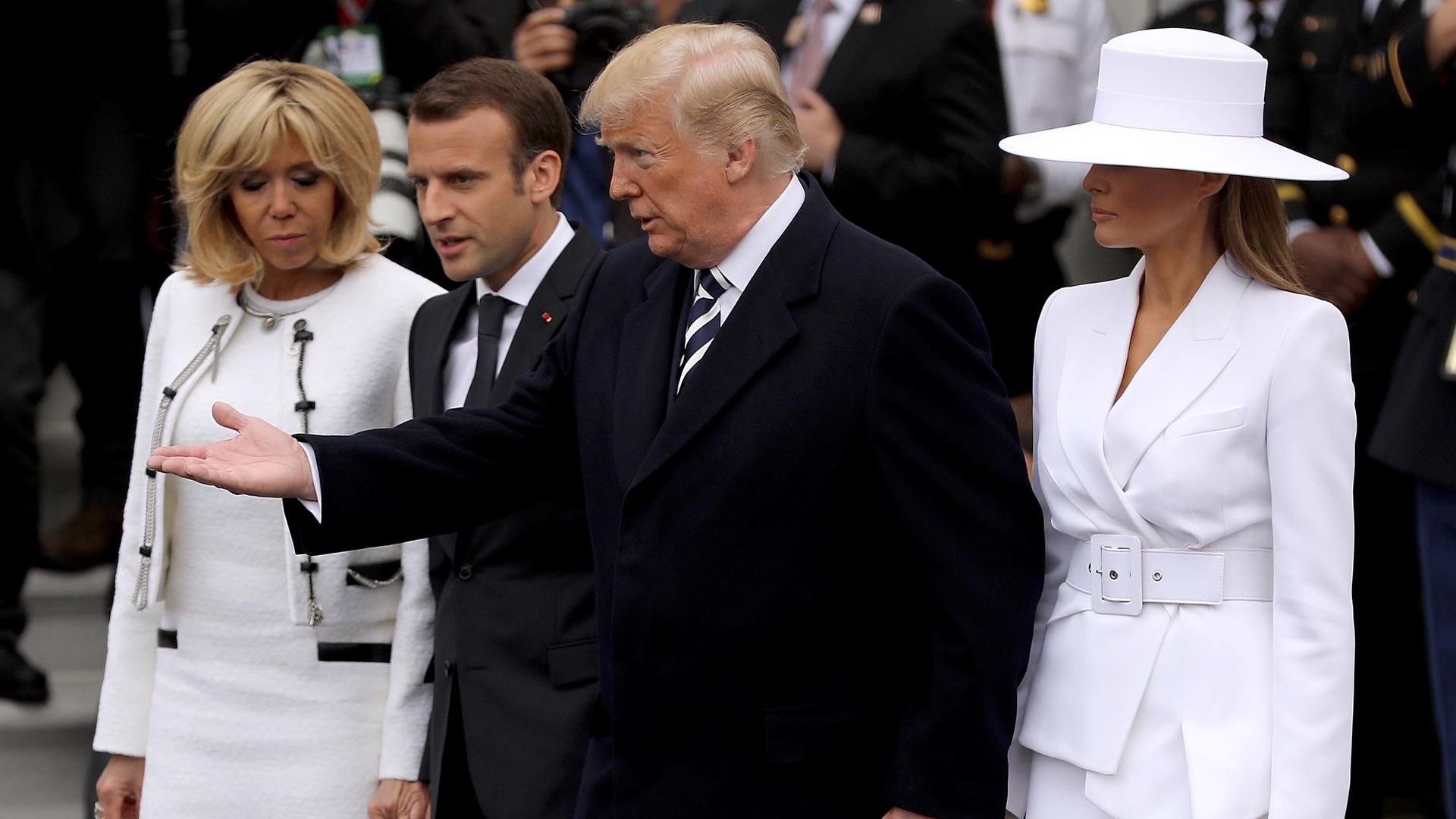 Trump walking with Emmanuel Macron, his wife Brigette and Melania Trump. 