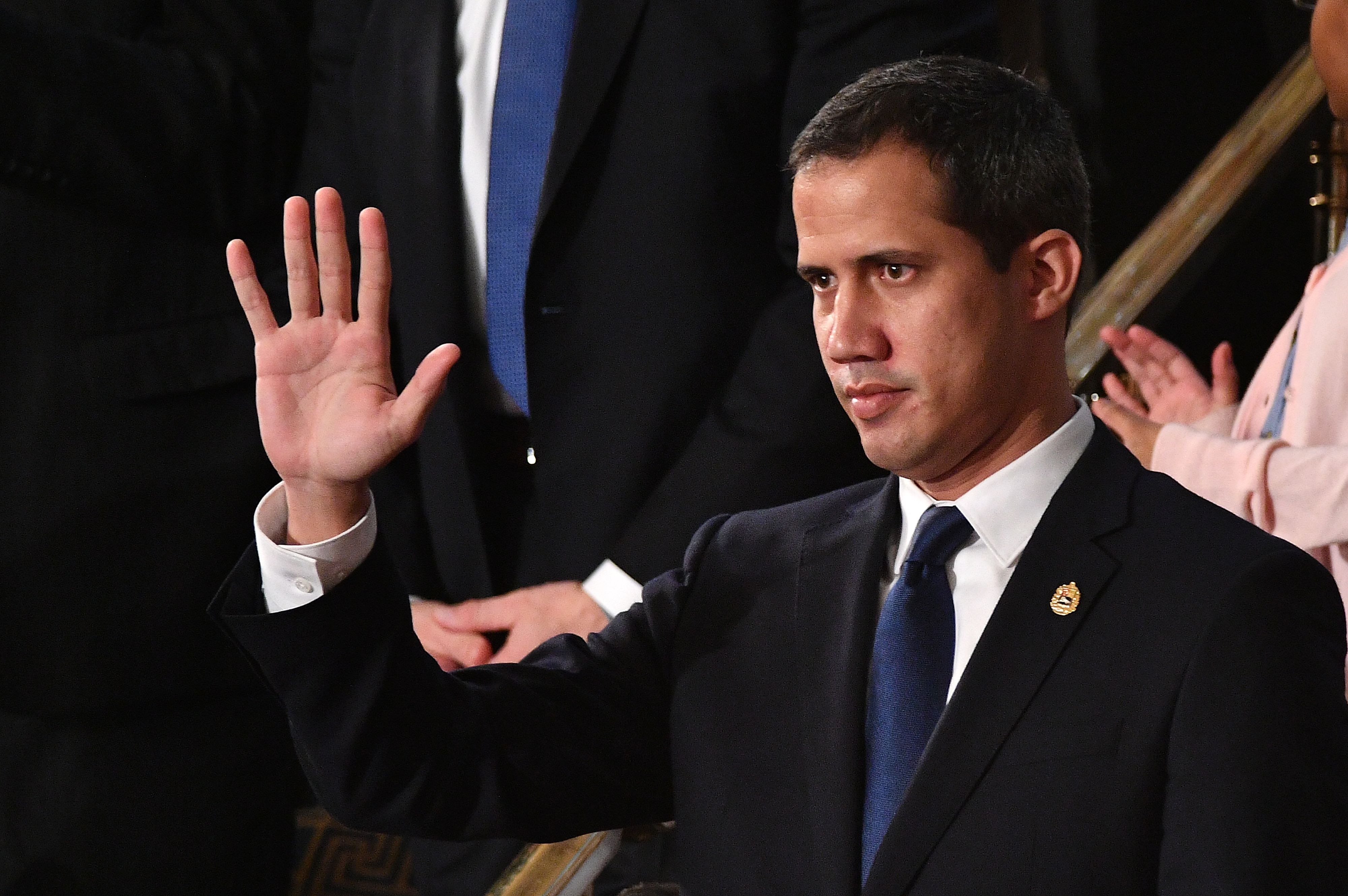 Venezuelan opposition leader Juan Guaido (C) waves as he is acknowledged by US President Donald Trump during his the State of the Union address at the US Capitol in Washington, DC, on February 4