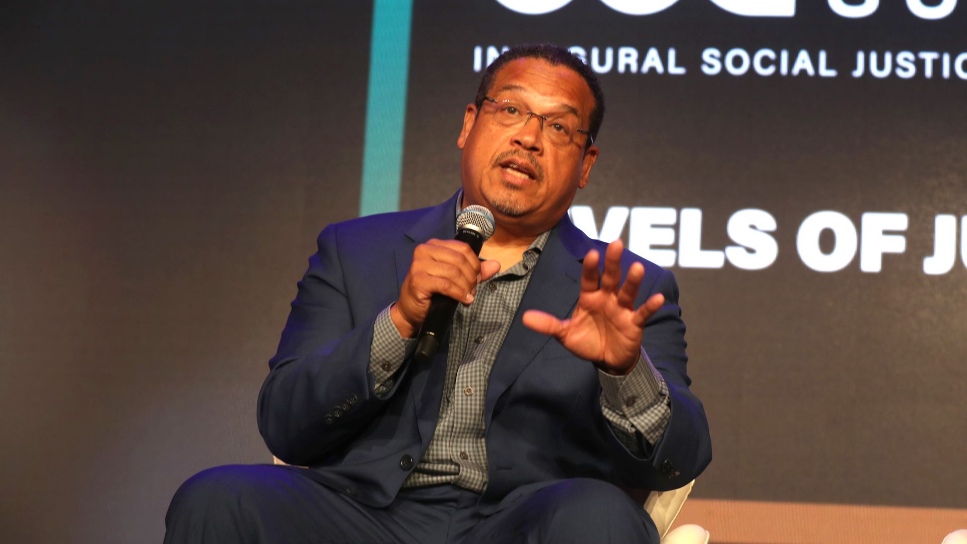 Keith Ellison speaks on stage at an event