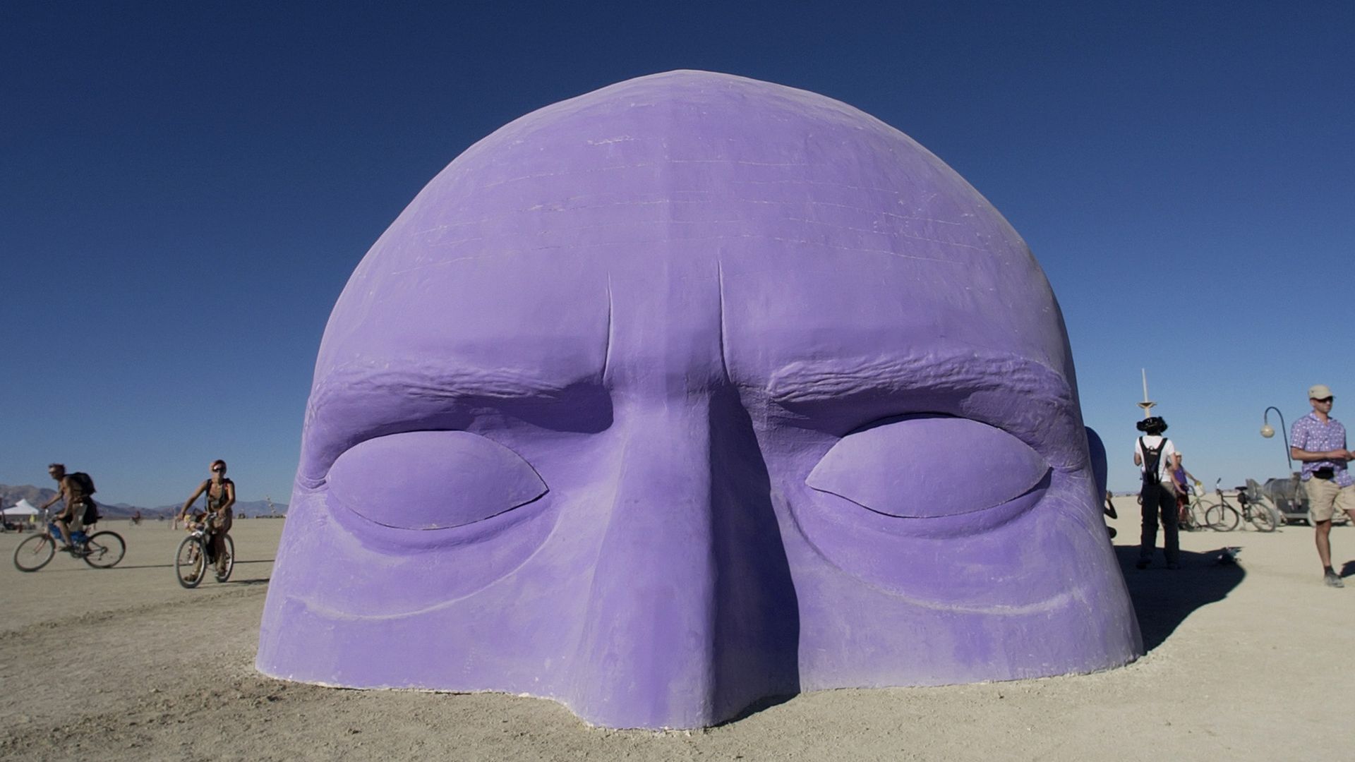 An art installation at Burning Man. It looks like a purple head rising out of the desert.