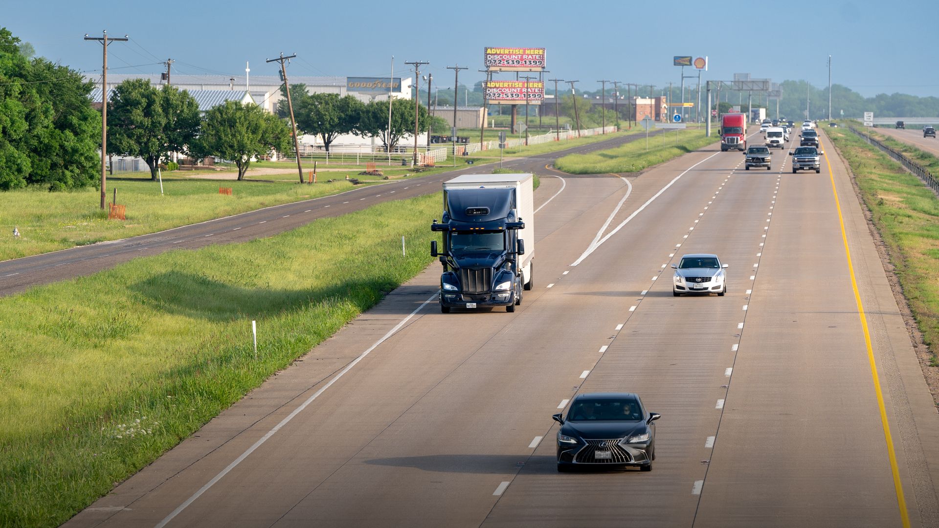 Image of a driverless semi truck merging into traffic on a three-lane interstate in Texas. 
