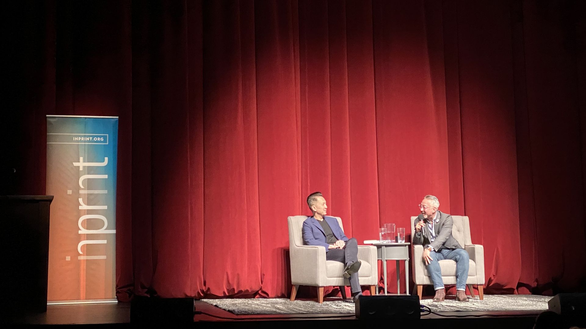 Two men on stage in conversation with each other. 