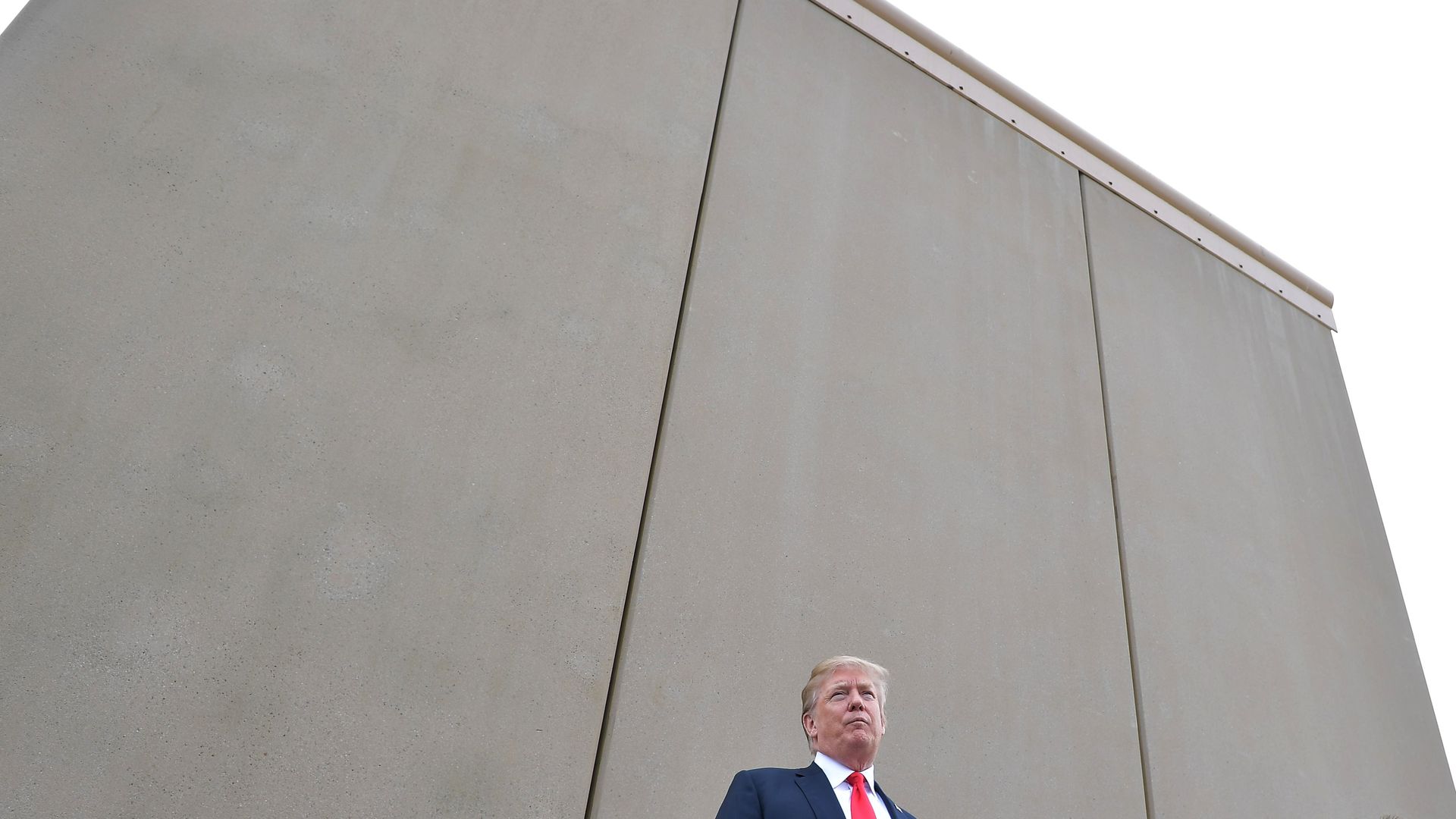 Donald Trump standing in front of border wall prototype