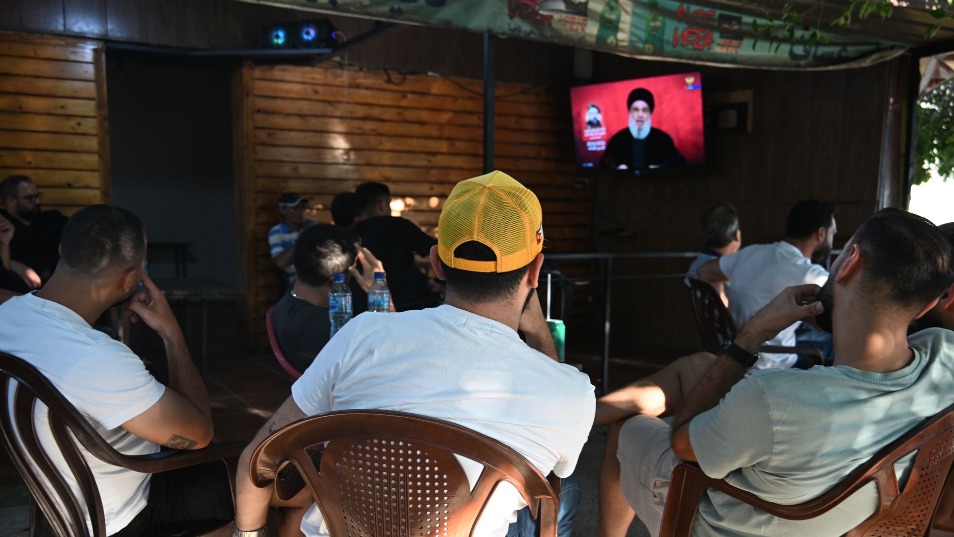 Citizens listen to the Secretary-General of Hezbollah, Hassan Nasrallah as he gives a speech through a video conference in Beirut, Lebanon on August 25, 2024.