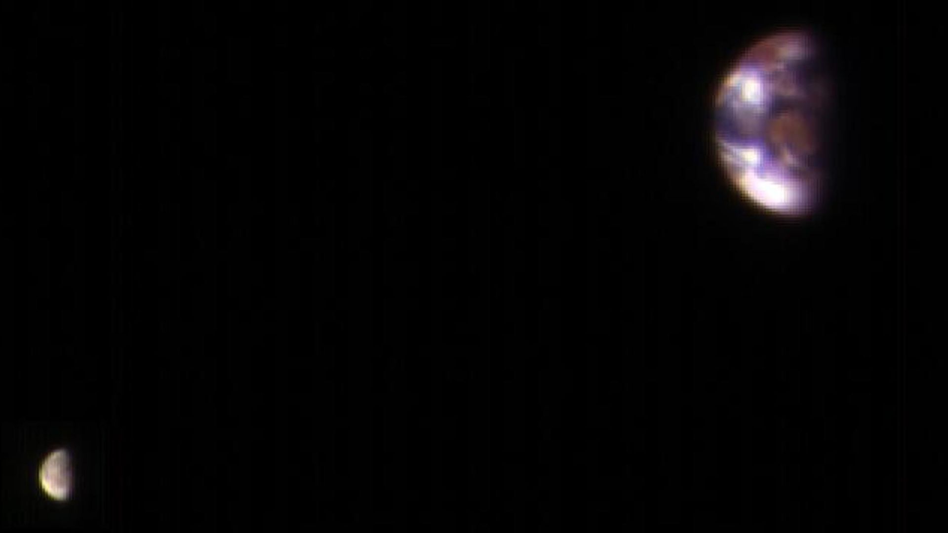 Earth and the Moon seen as blurry, colorful dots from Mars