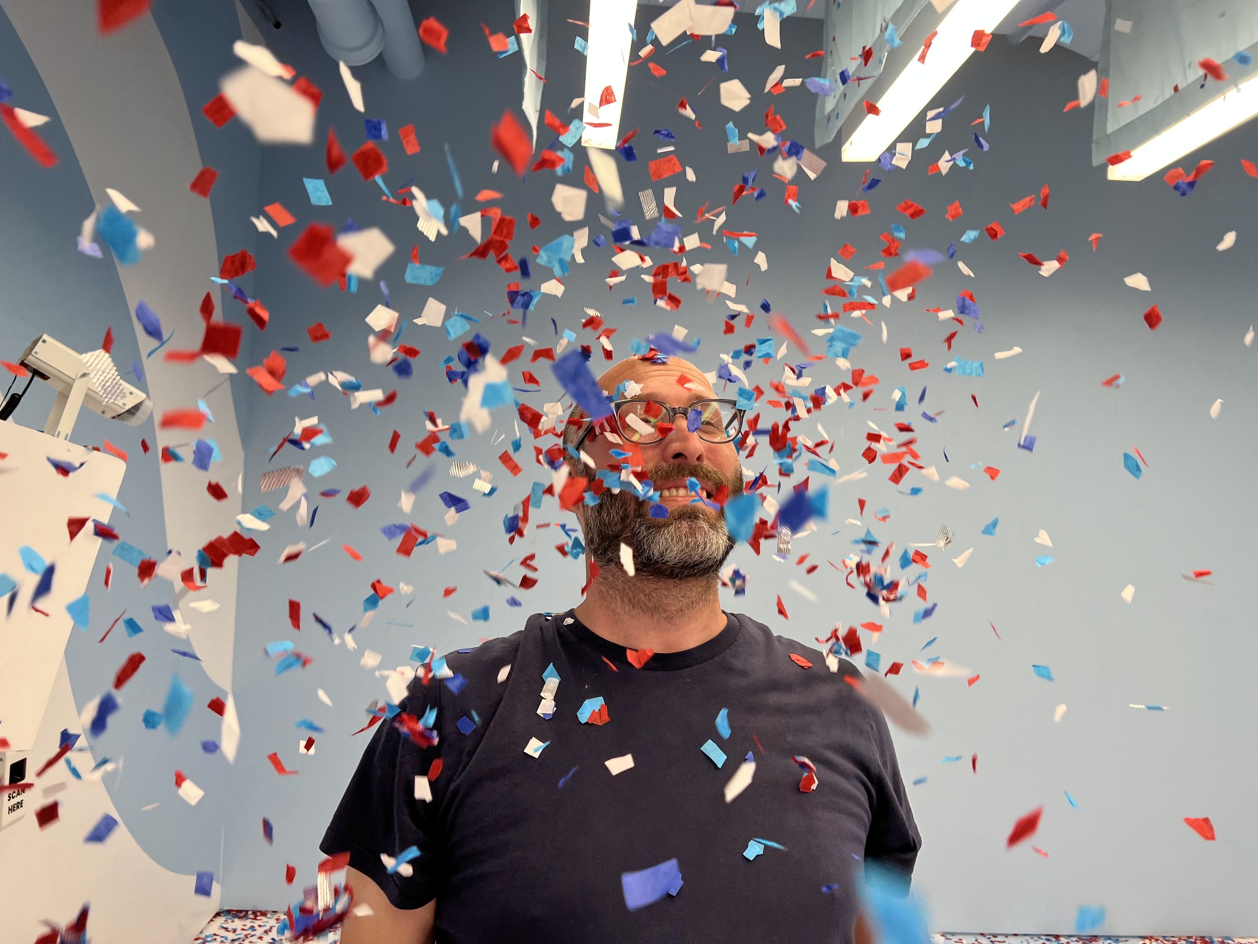Photo of a man getting showered with confetti. 