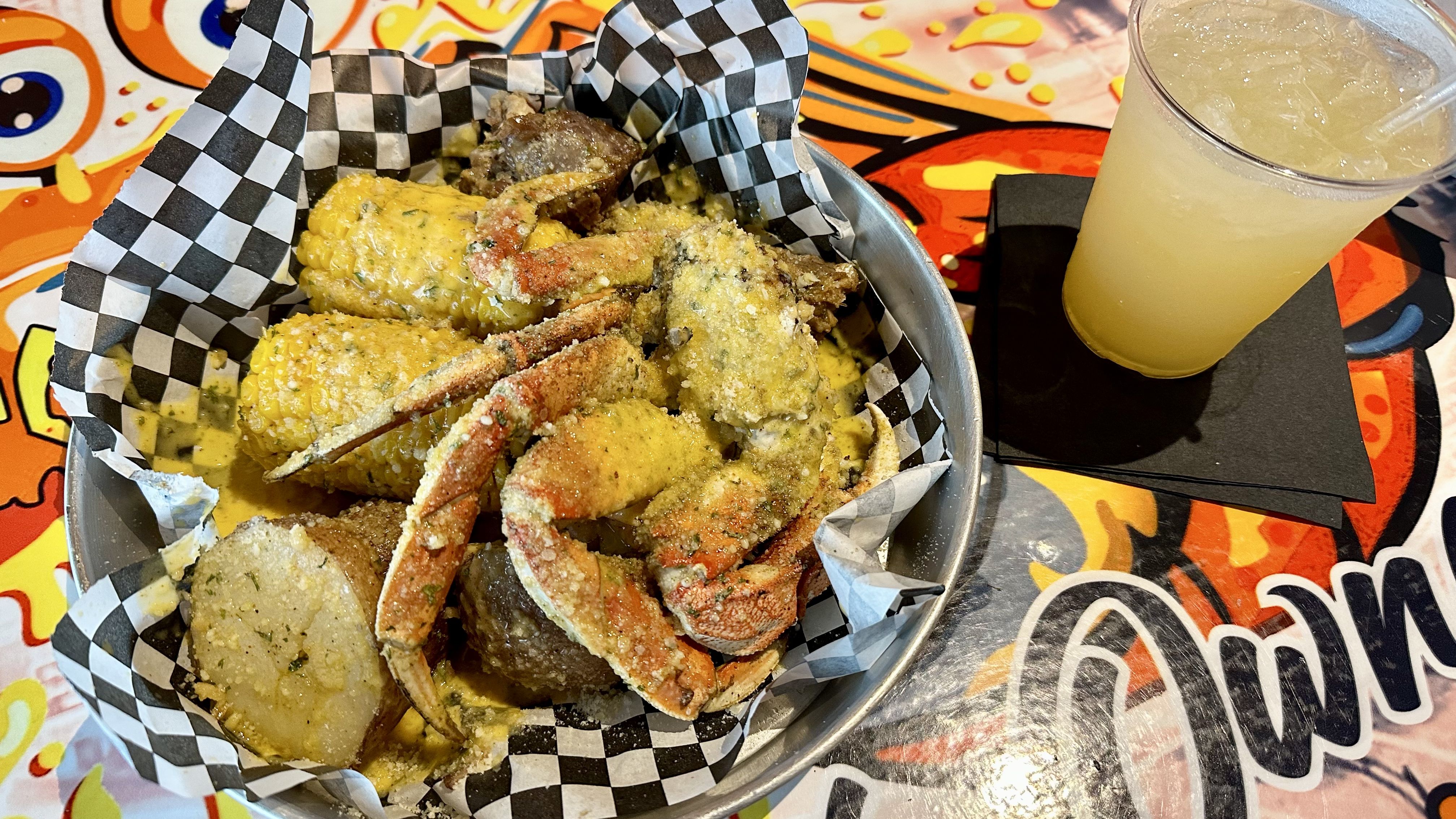 Photo shows a plate of boiled seafood and a peach cocktail.