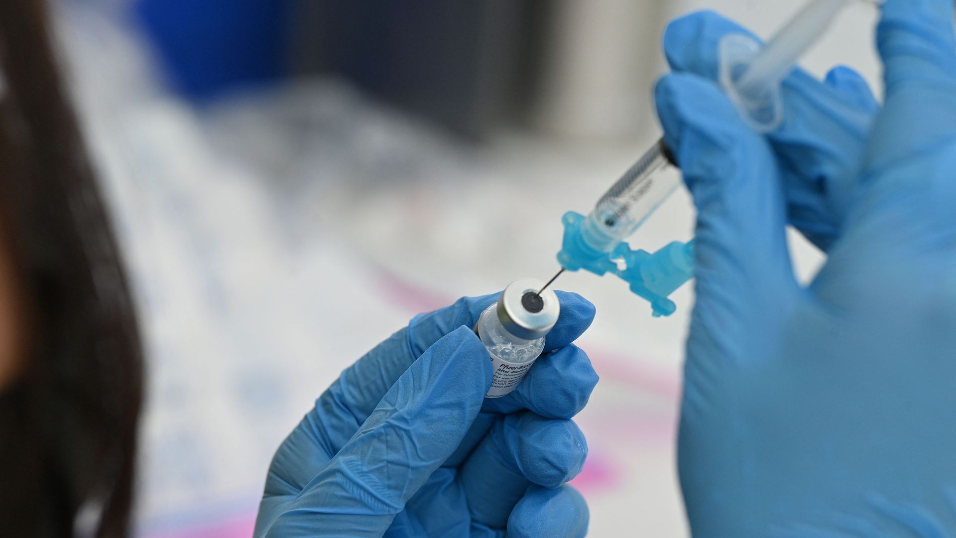A healthcare worker fills a syringe with Pfizer Covid-19 vaccine syringe