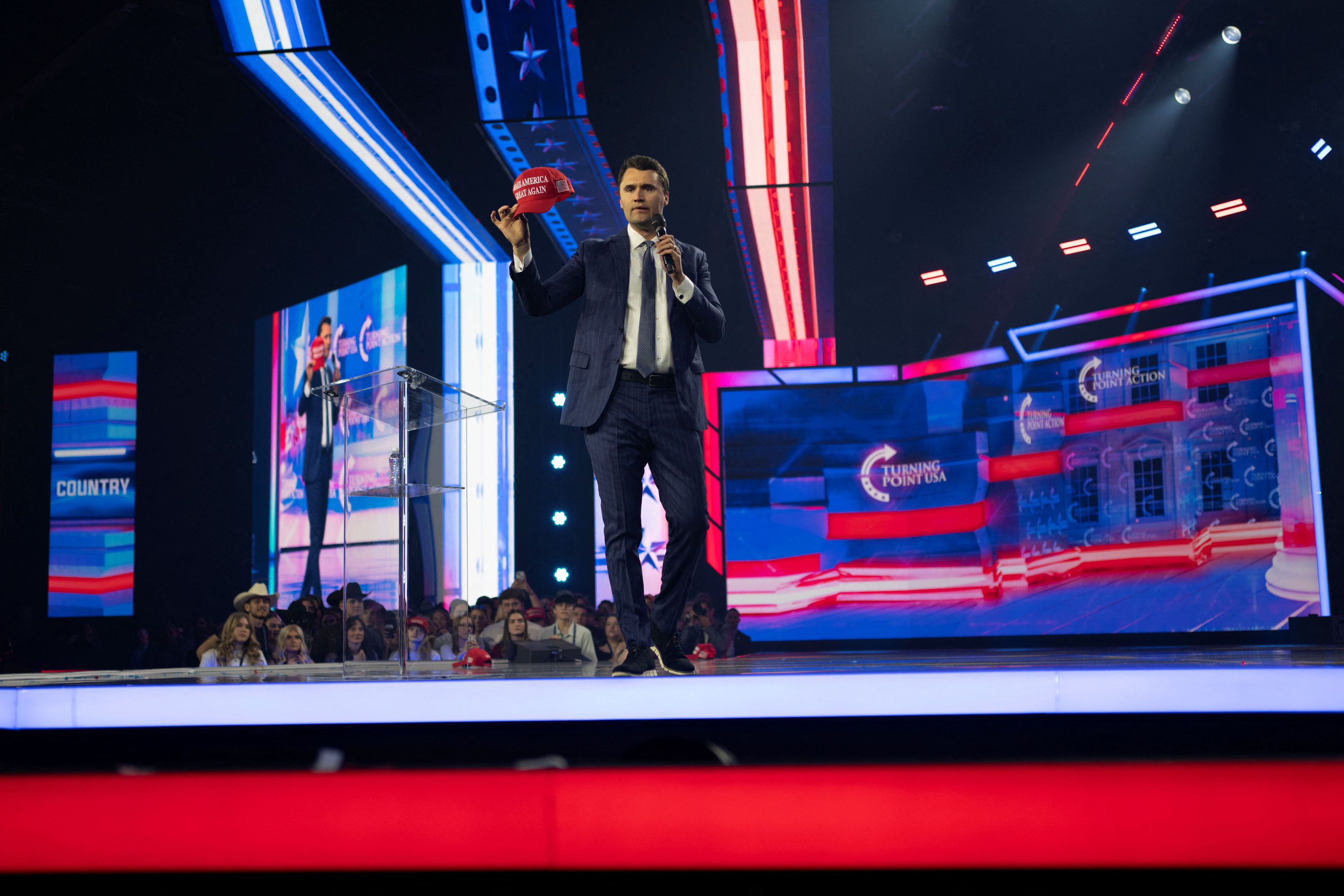 Charlie Kirk, Turning Point USA founder, holds up a MAGA hat during the AmericaFest 2024 conference sponsored by conservative group Turning Point in Phoenix, Arizona, U.S. December 19, 2024. REUTERS/Cheney Orr