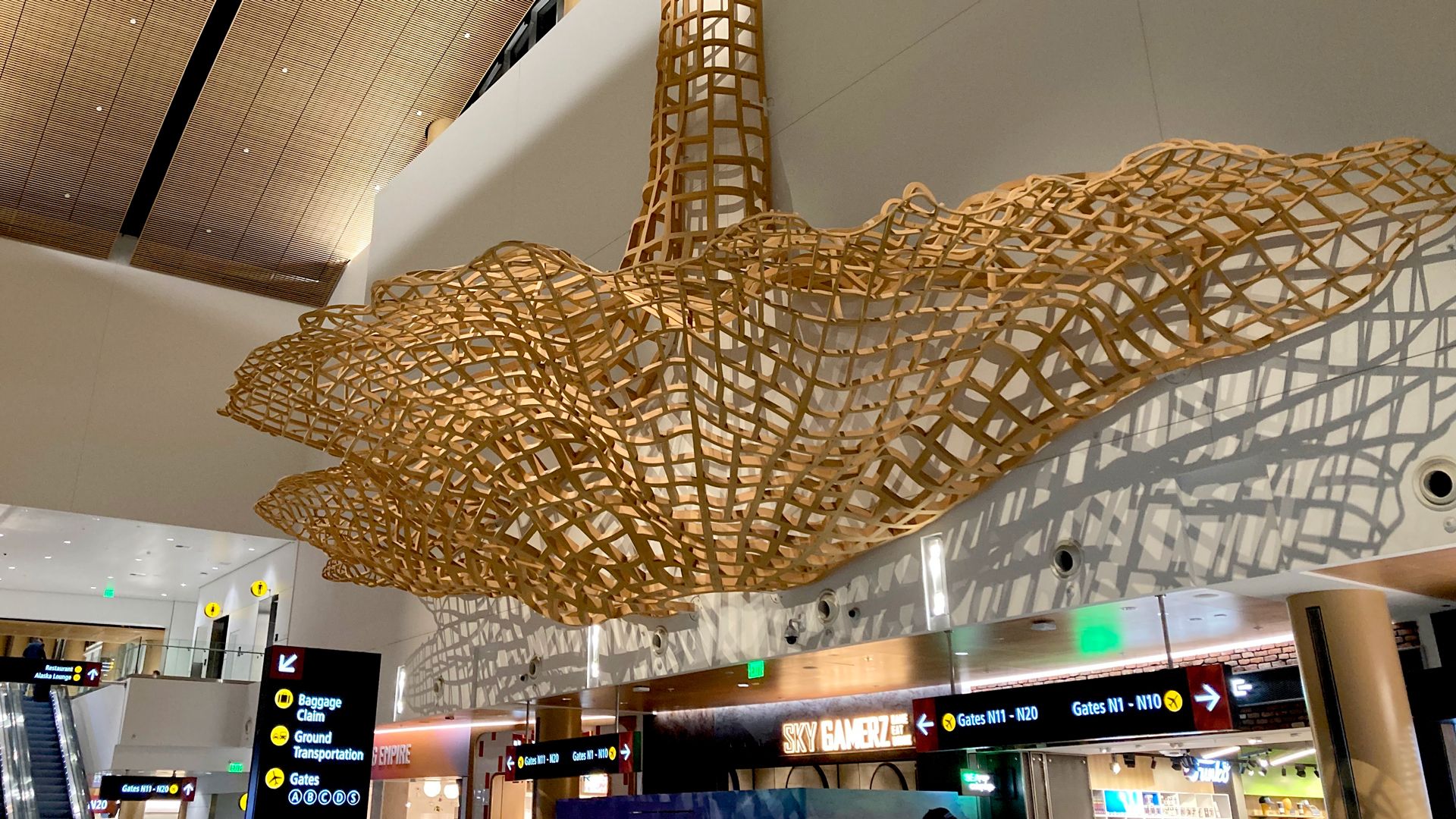 An image of a wooden sculpture that looks like tree roots at SeaTac airport.