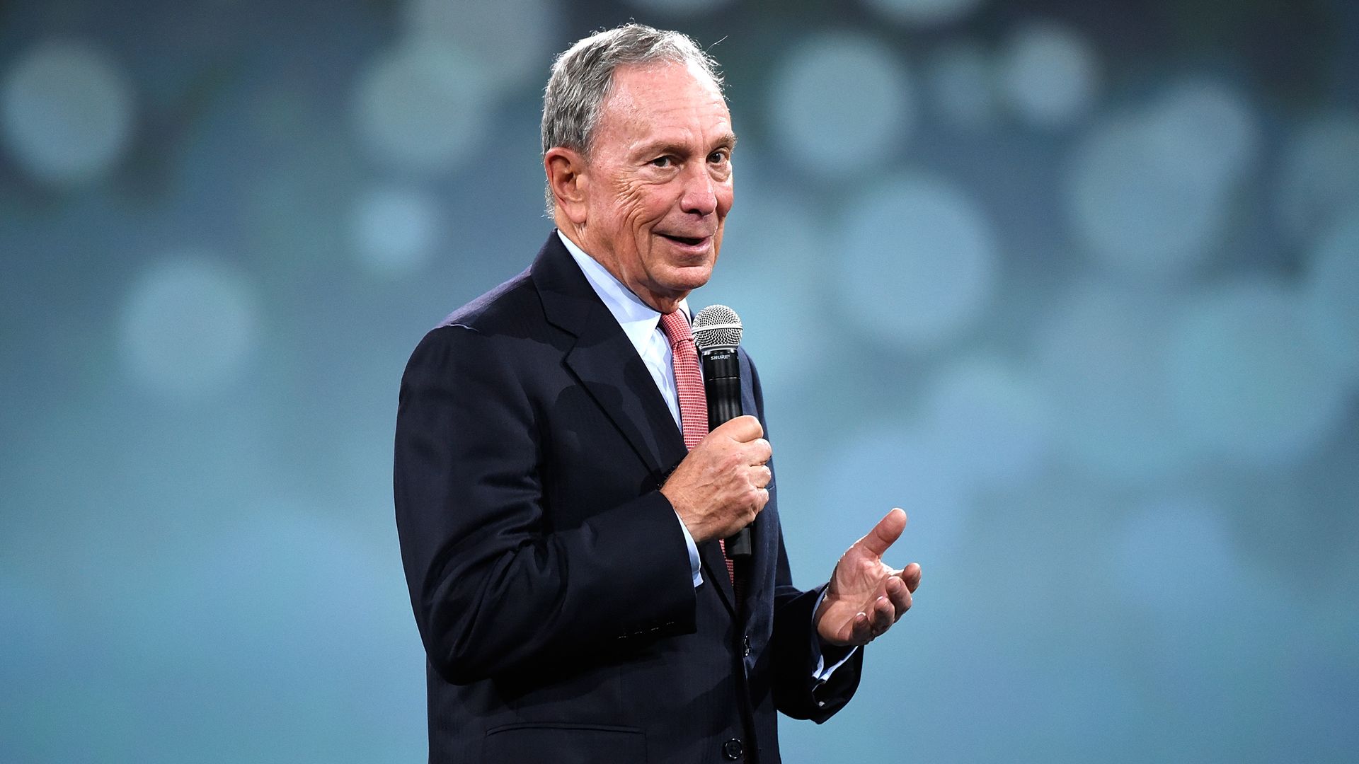 Mike Bloomberg smiles on stage