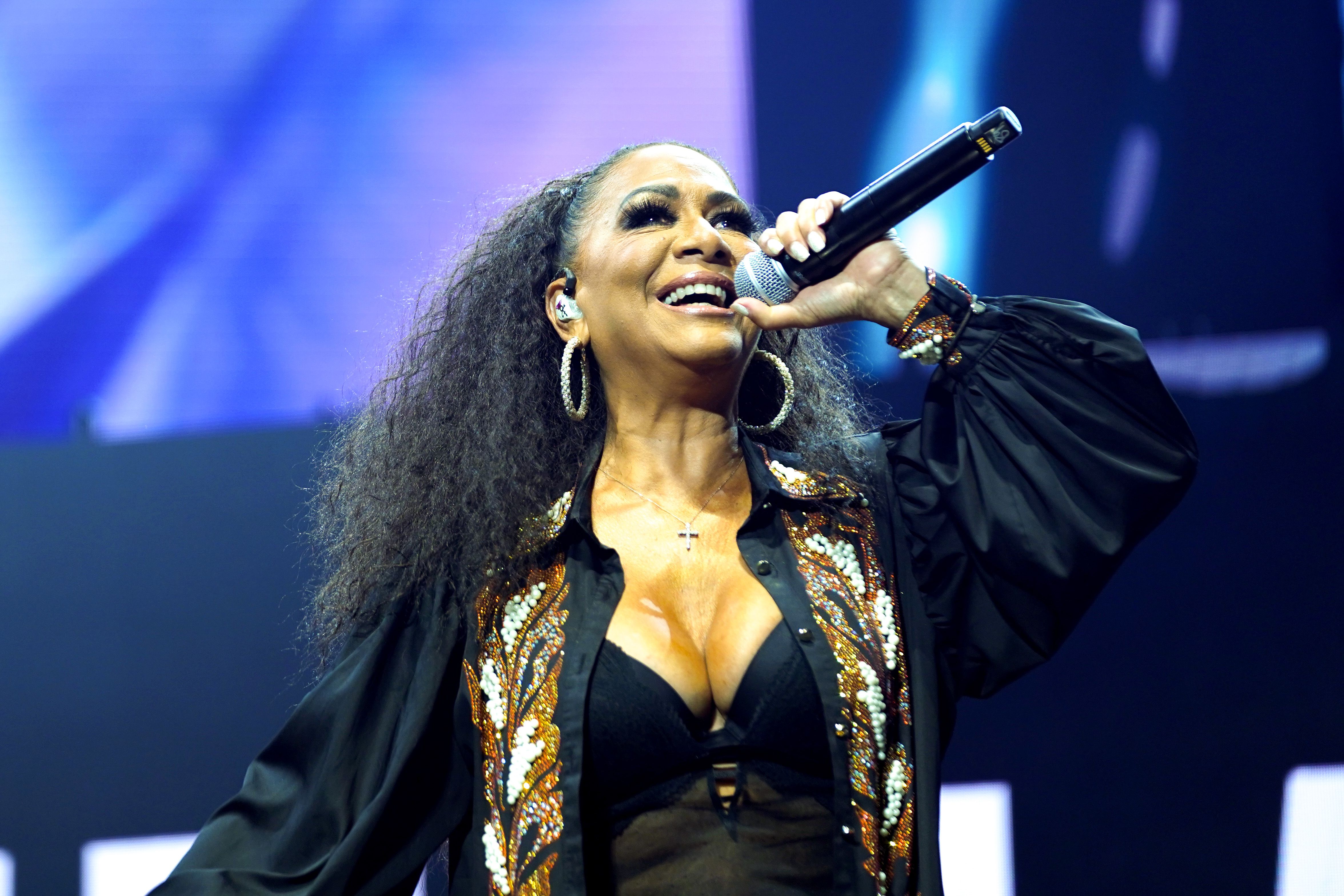 Photo shows Sheila E. performing with a mic.