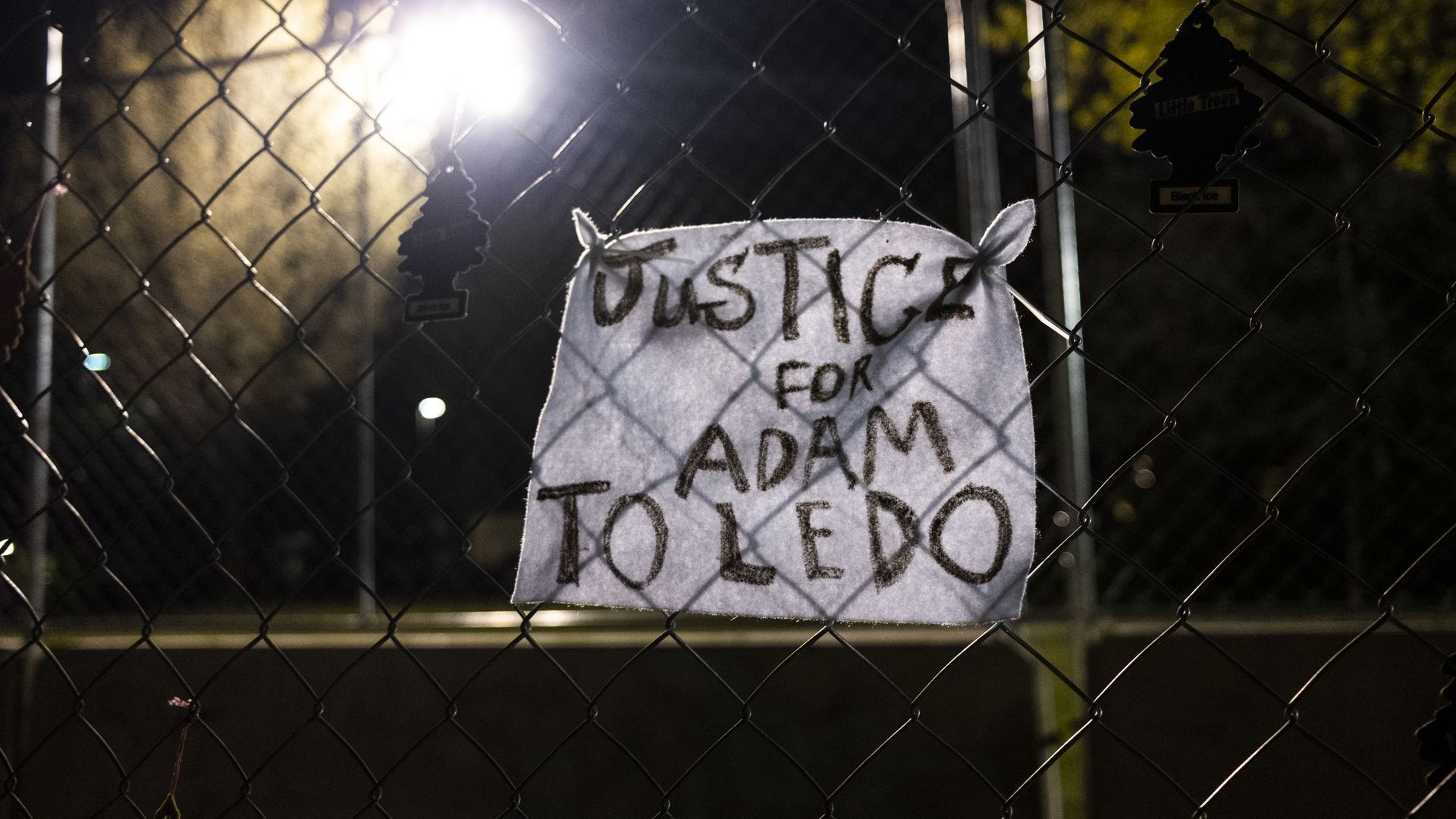 A piece of cloth tied to a fence in Brooklyn Center, Minn., demands justice for Adam Toledo. Photo: Stephen Maturen/Getty Images