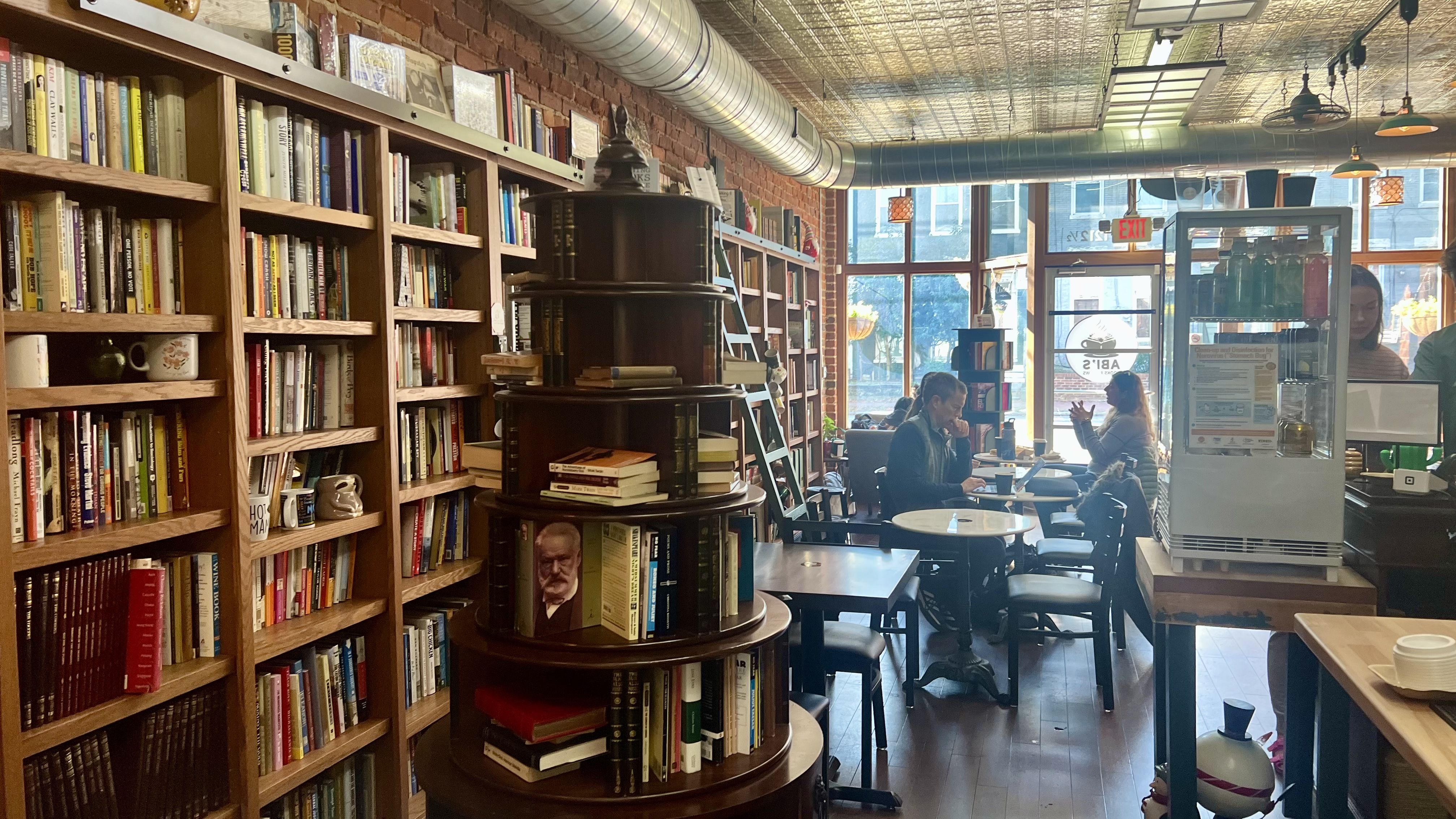 The inside of a coffee shop that looks like a floor-to-ceiling library. 