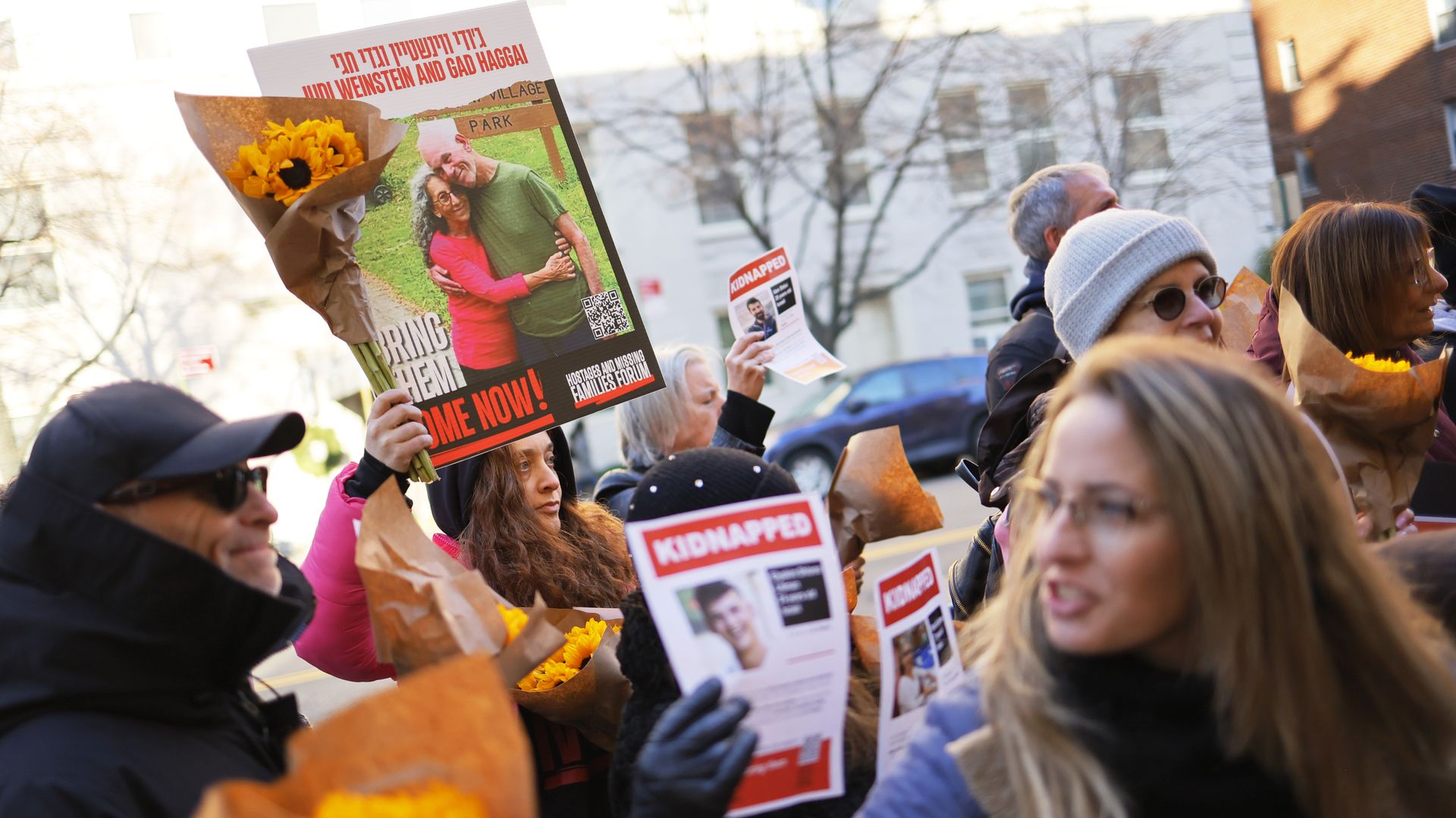 Protesters hold up signs showing people held hostage in Gaza.