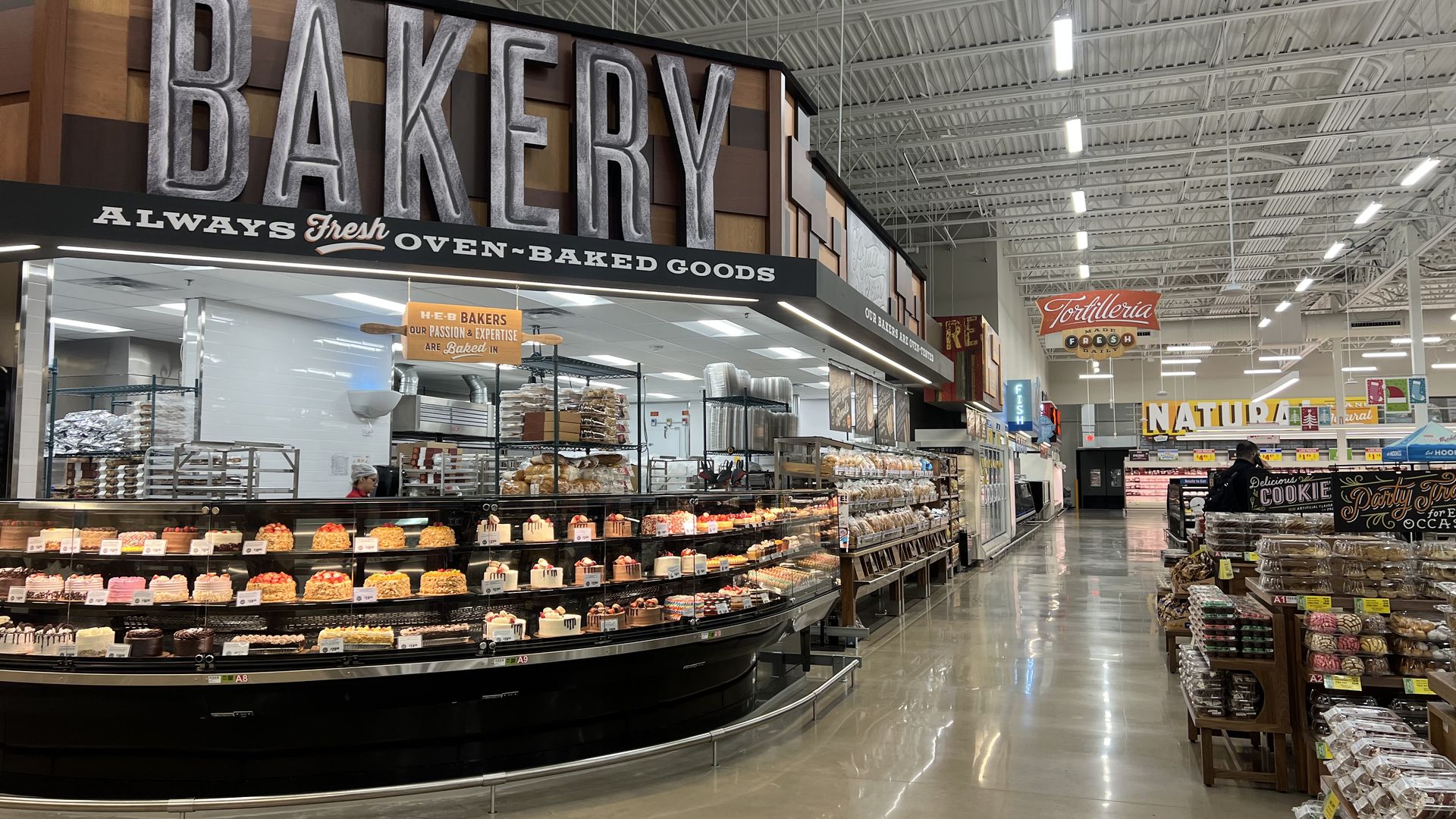 A photo of a sign reading "bakery" with baked goods in a counter under it.