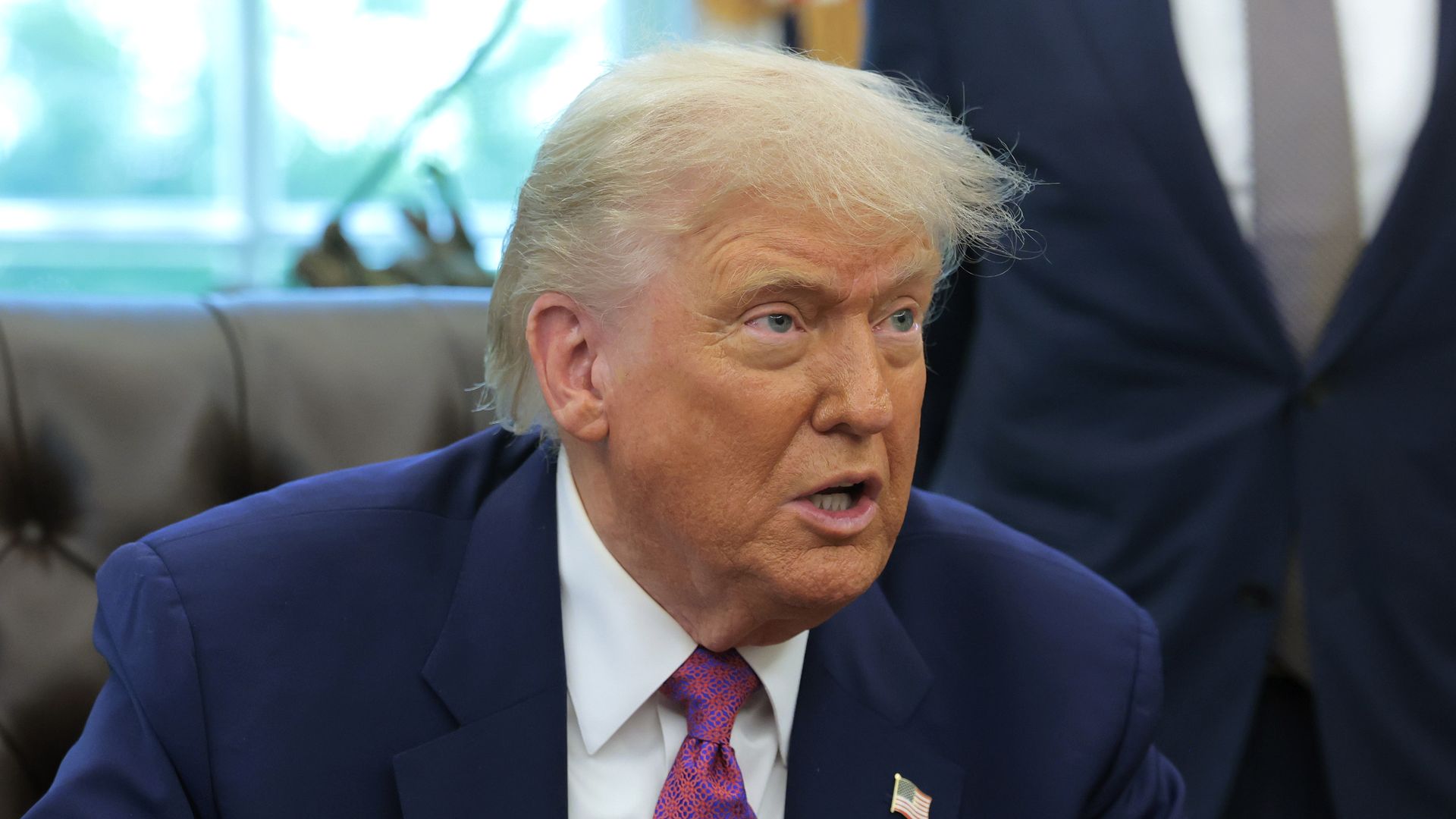 President Trump sits as he speaks from the Oval Office of the White House.