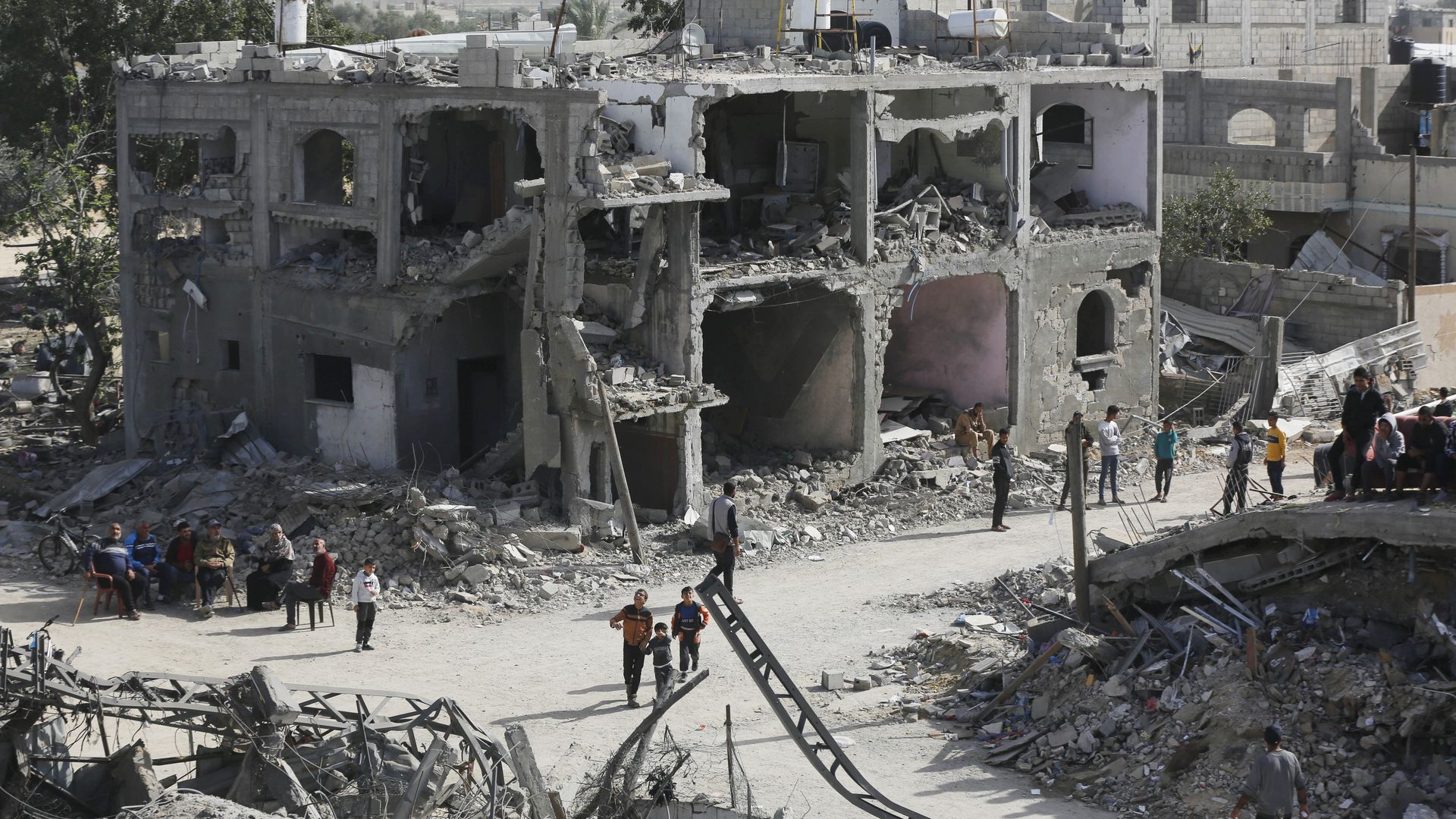 Palestinians in Khan Yunis walk in residential areas destroyed in Israel's bombardment of Gaza.